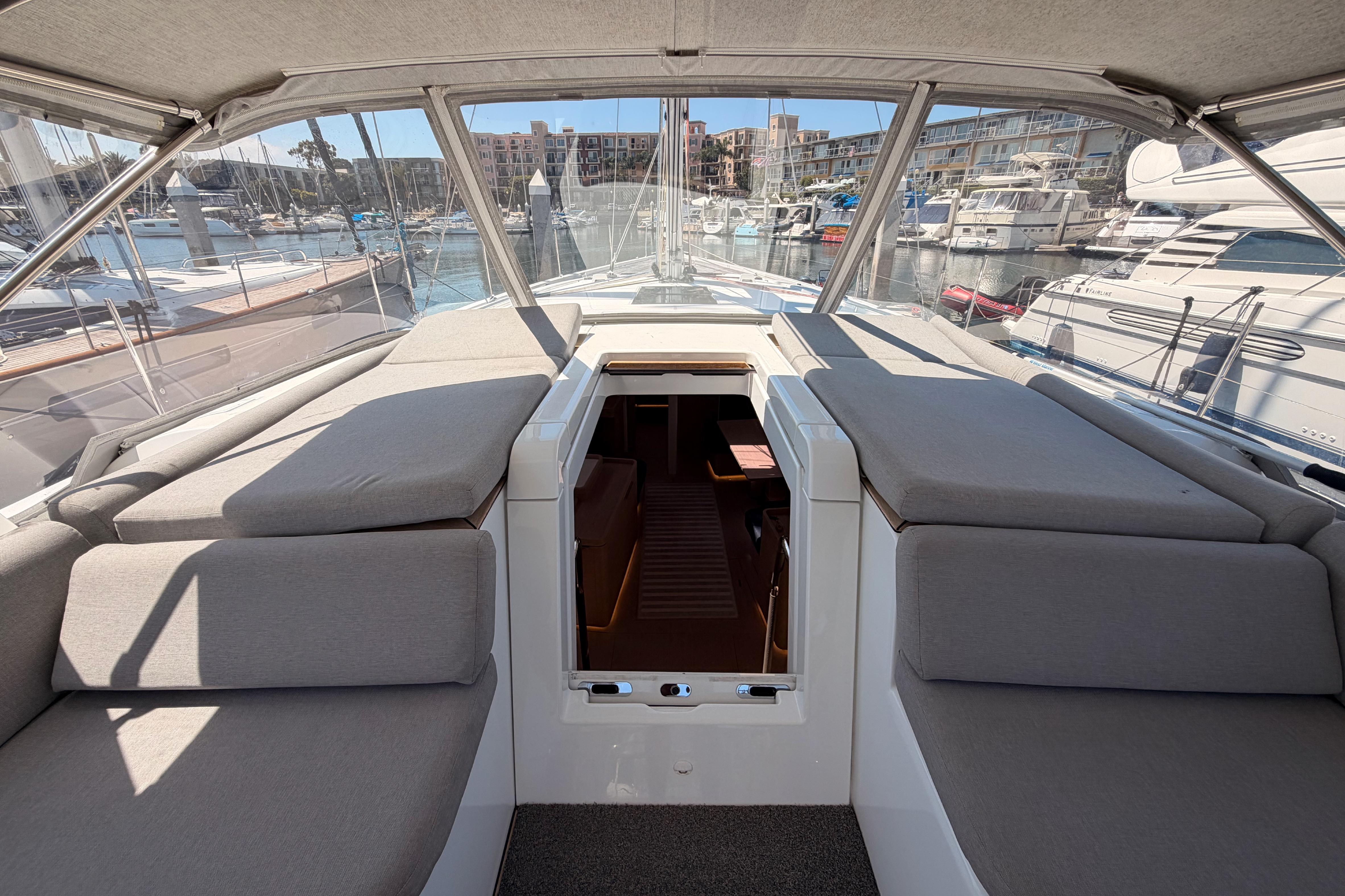 Luxurious 2022 Beneteau Oceanis Yacht 54 cockpit with comfortable seating and marina view.