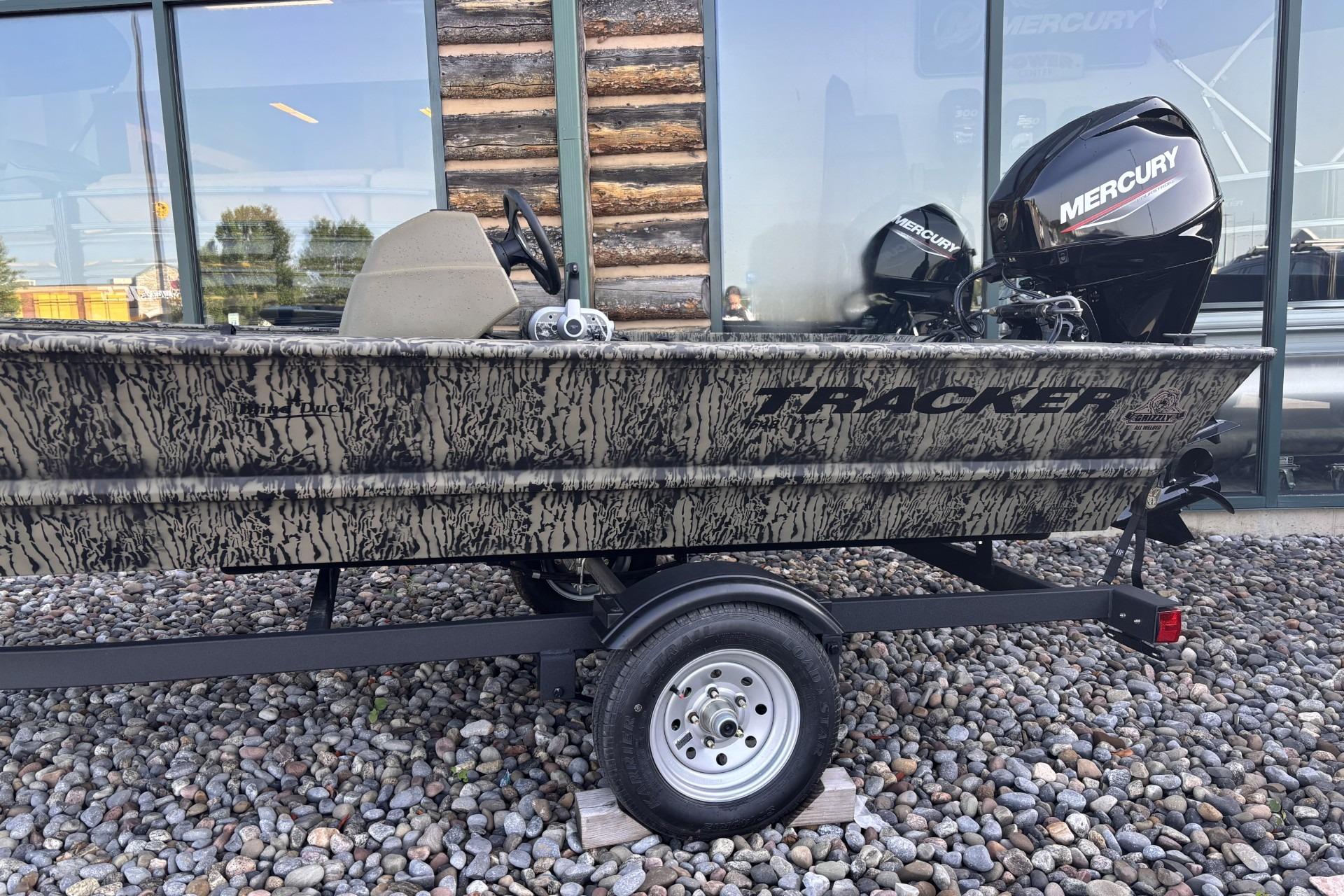 2026 Tracker Grizzly 1648 SC boat with Mercury engine on trailer, camo design.