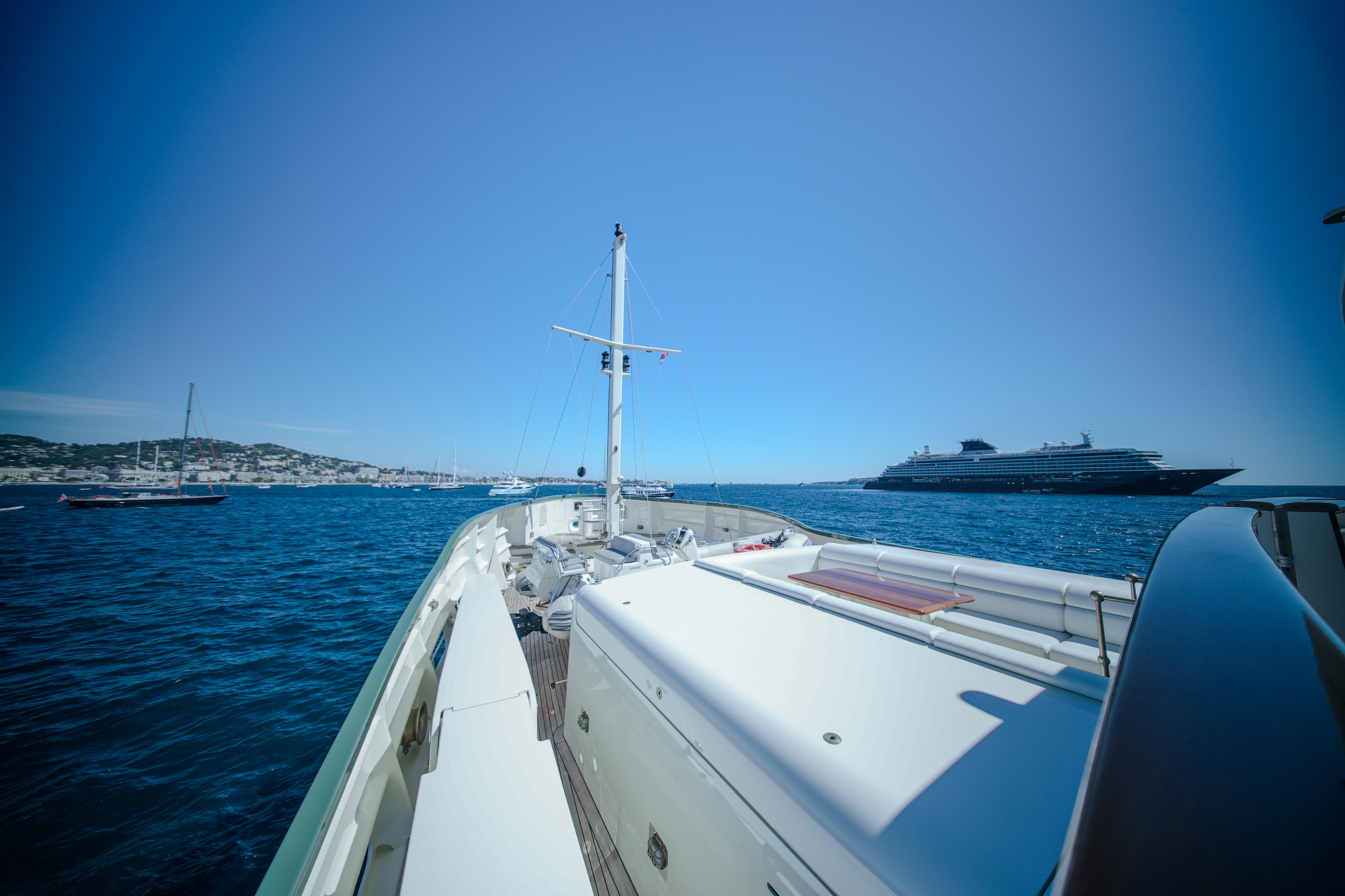 Pendennis 55 yacht cruising in blue waters, 2009 model, with distant ships and coastline.