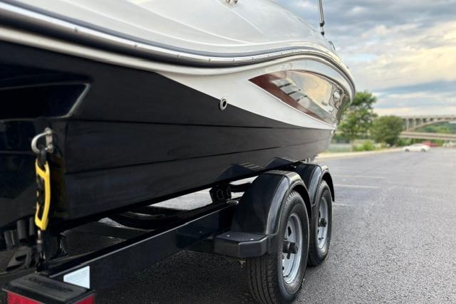 2017 Searay SPX210 boat on trailer in parking lot, overcast sky.