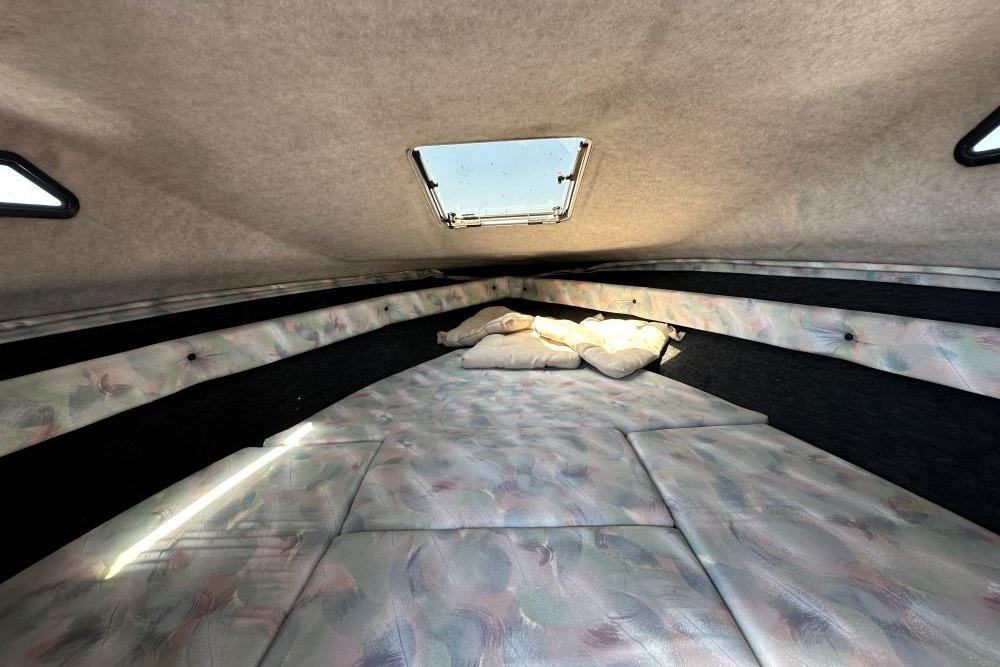 Interior cabin of a 1992 Reinell 192 RM boat with cushioned seating and overhead hatch.