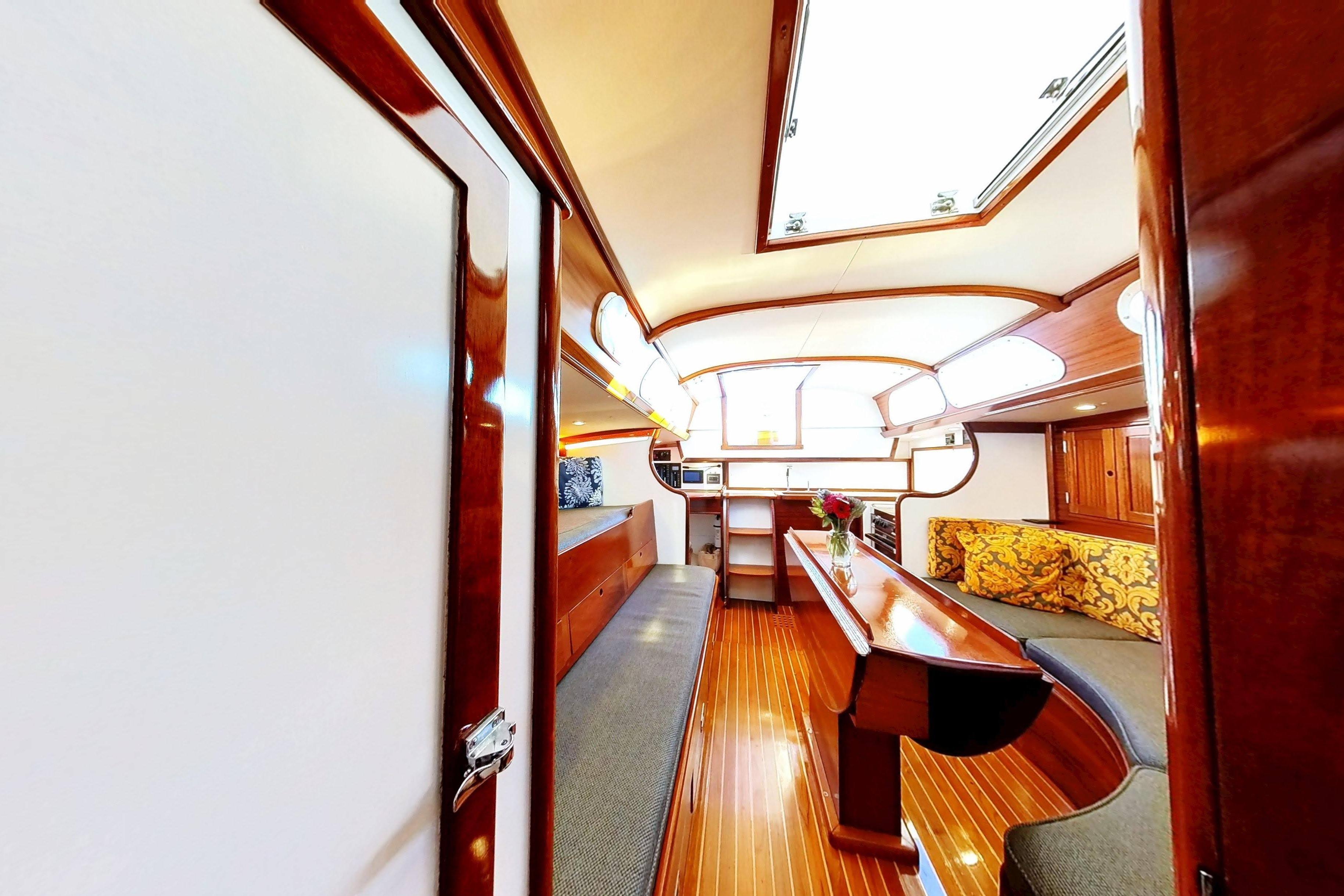Interior of a 1970 Hinckley Bermuda 40 sailboat with polished wood and cozy seating.