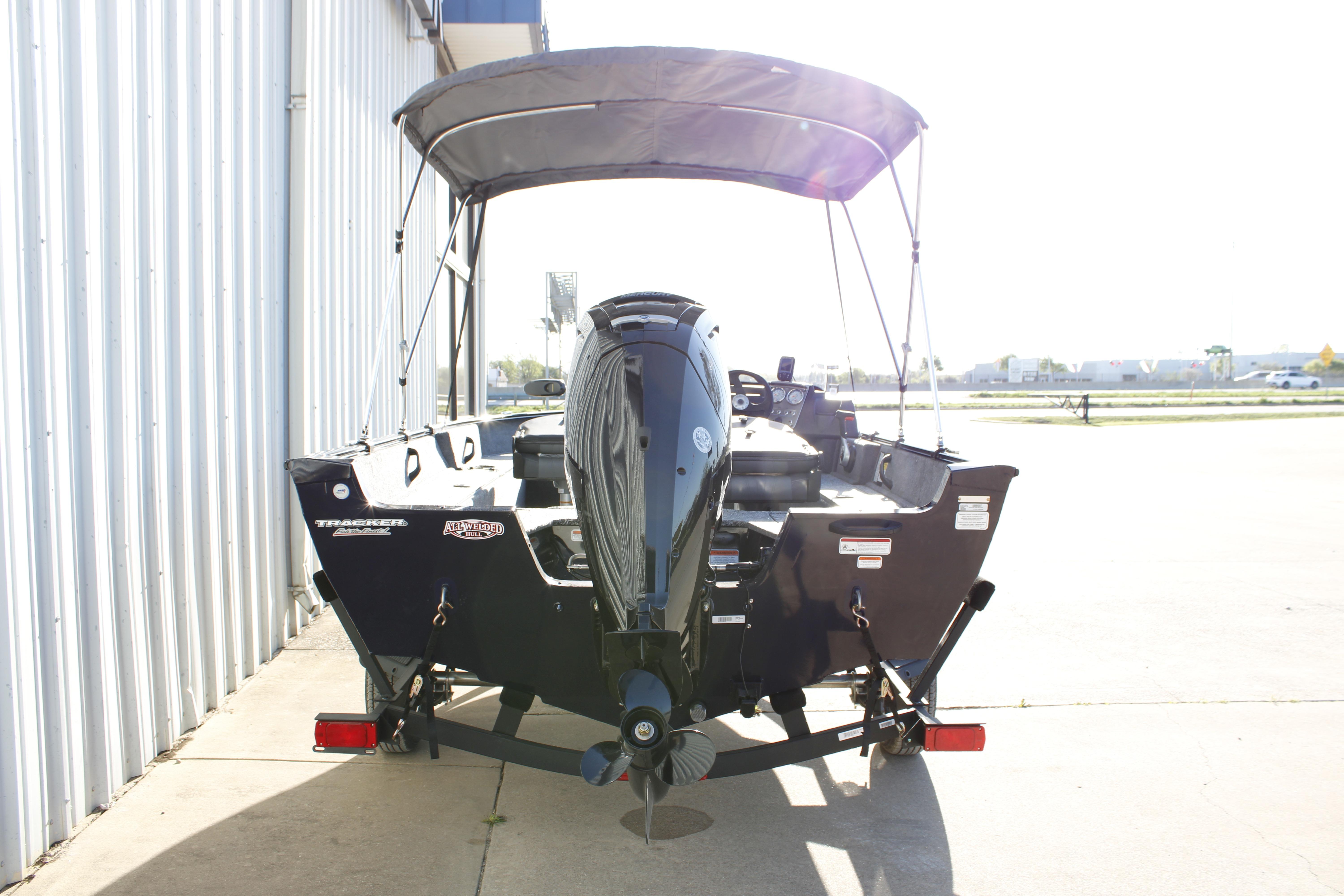 2026 Tracker Pro Guide V-16 SC boat with canopy, parked outdoors.