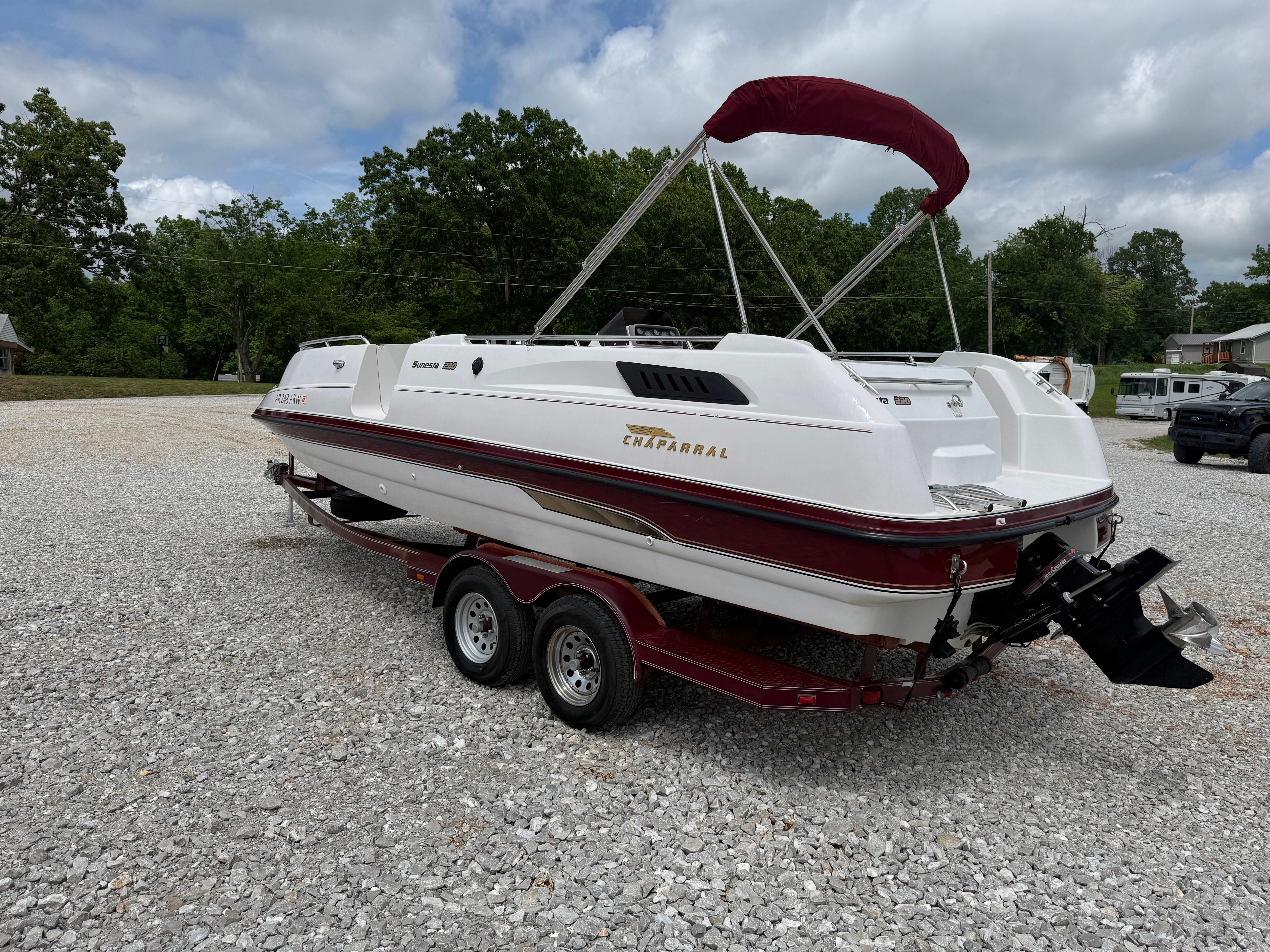 A 1994 Chaparral Sunesta 220 on a trailer in a gravel lot.