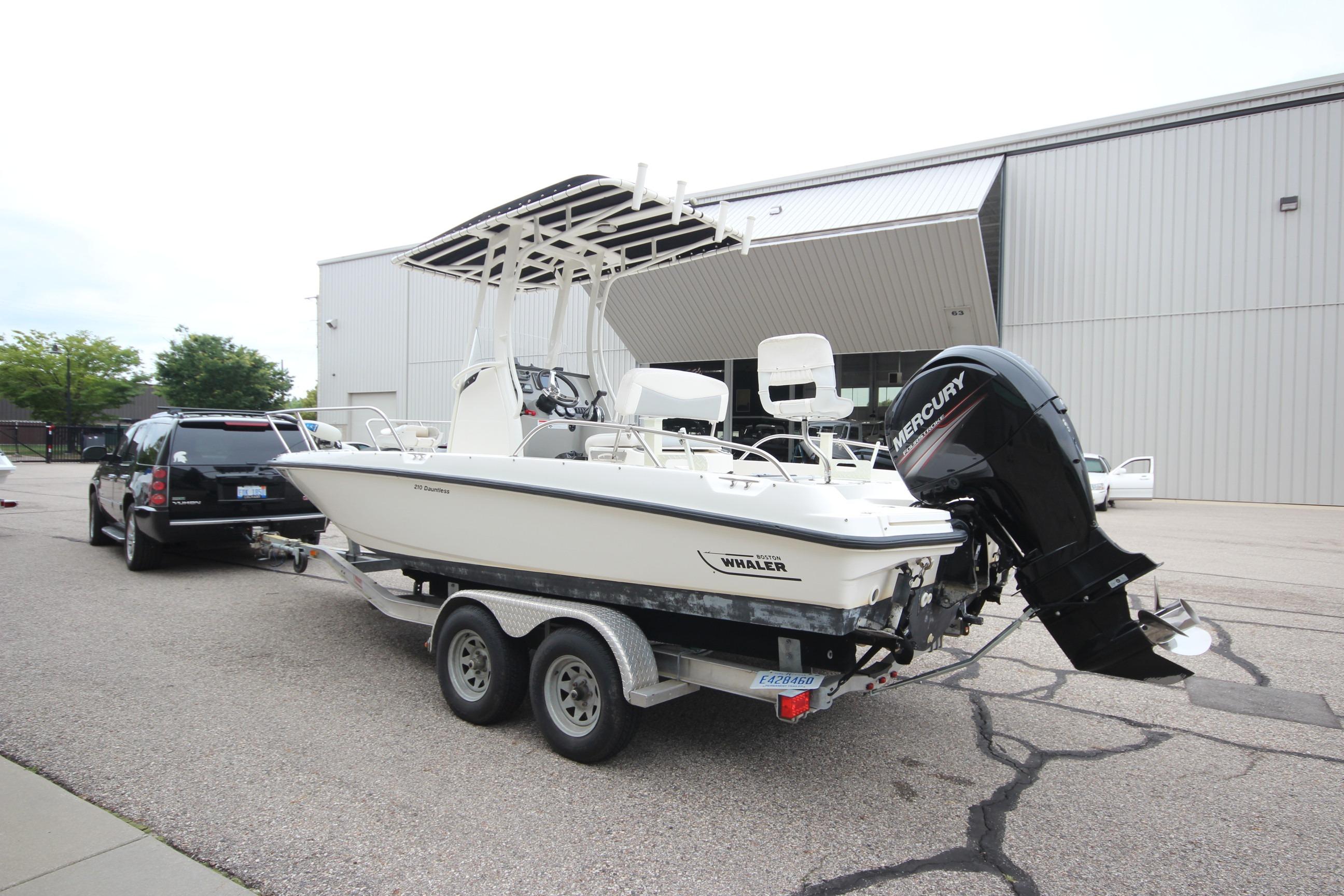 2014 Boston Whaler 210 Dauntless boat on trailer, parked near a building.