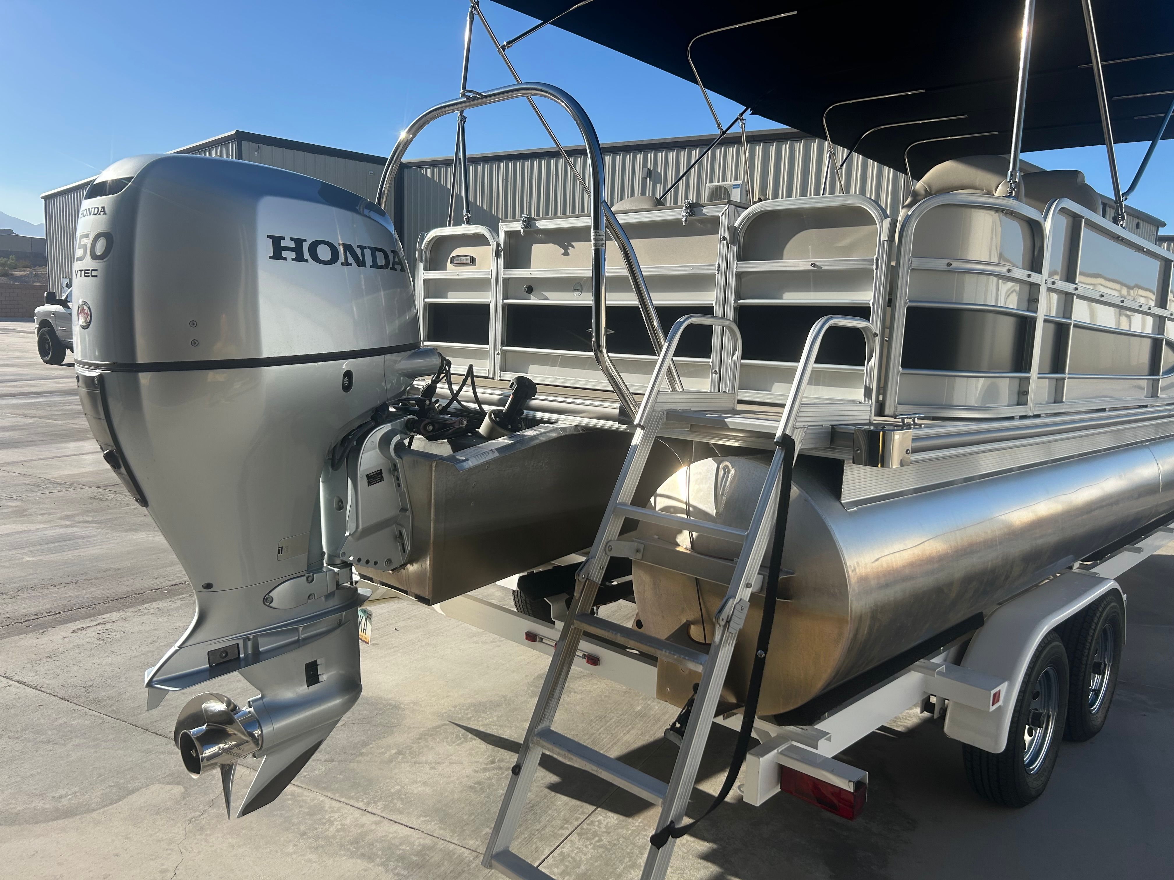 A 2018 Berkshire 24RFX CTS pontoon boat with a Honda outboard motor. It is on a trailer.