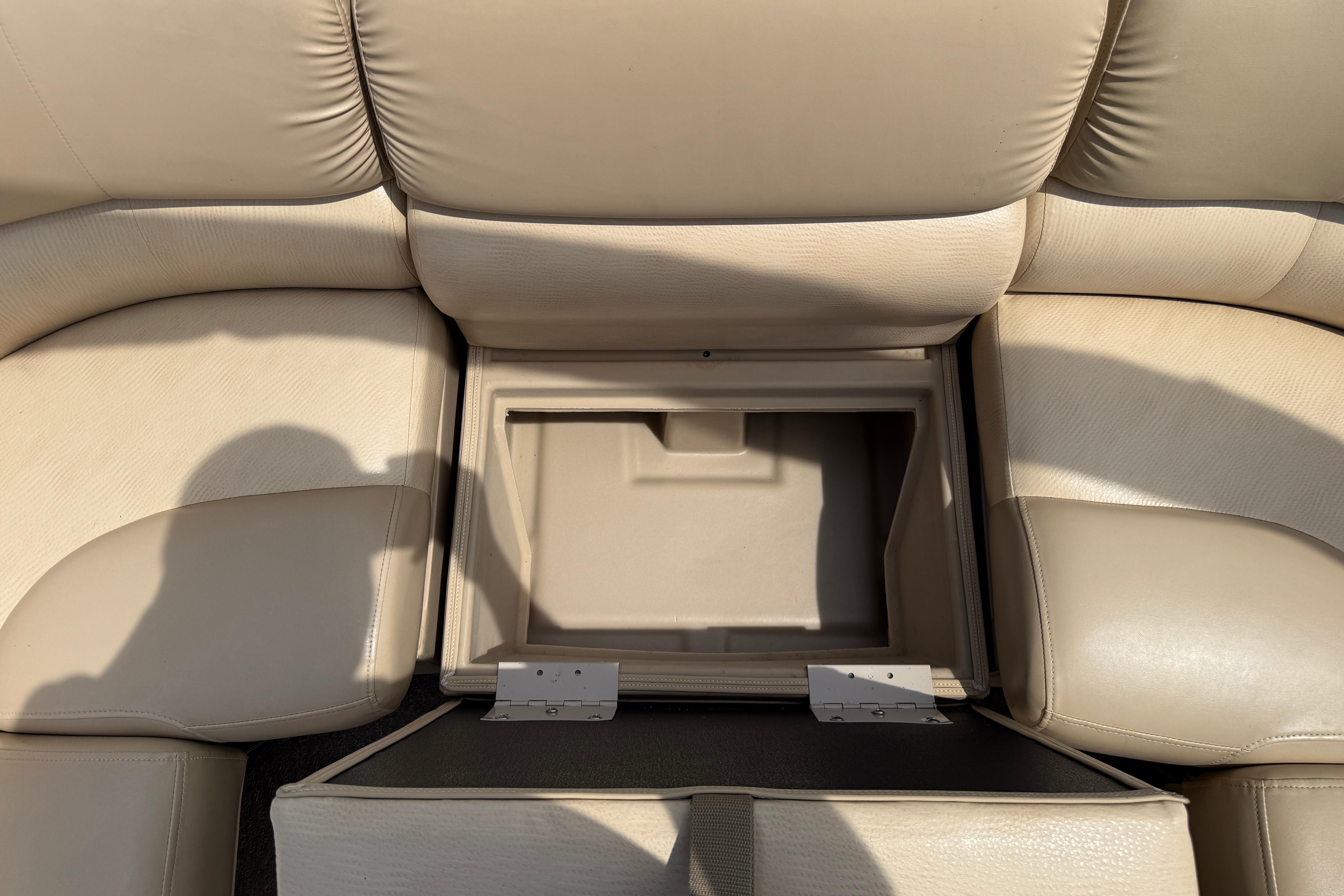 2011 Bennington 2575QCW I/O boat interior storage compartment with beige leather seating.