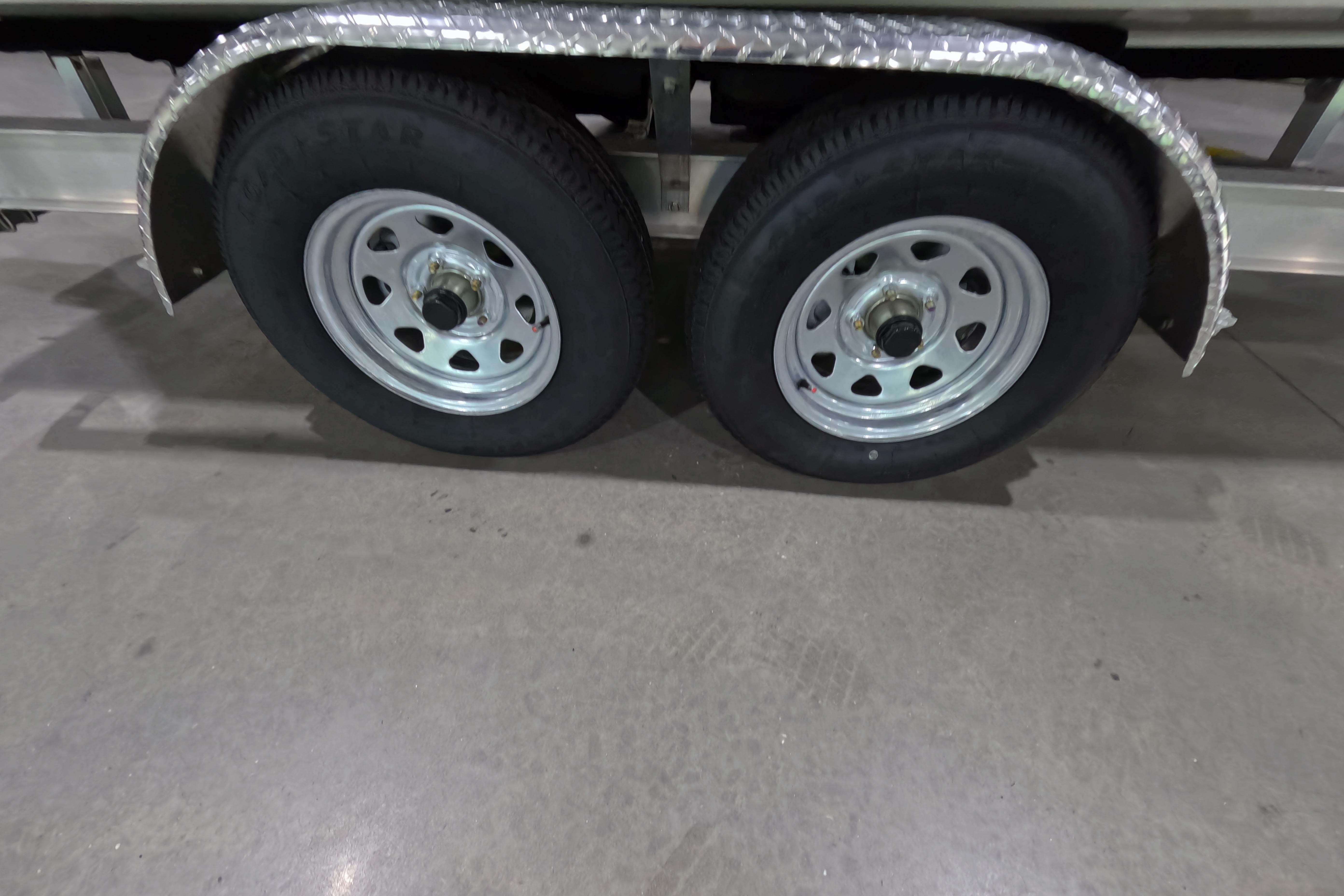 Dual wheels on a 2026 Skeeter trailer with metal fenders, parked indoors.