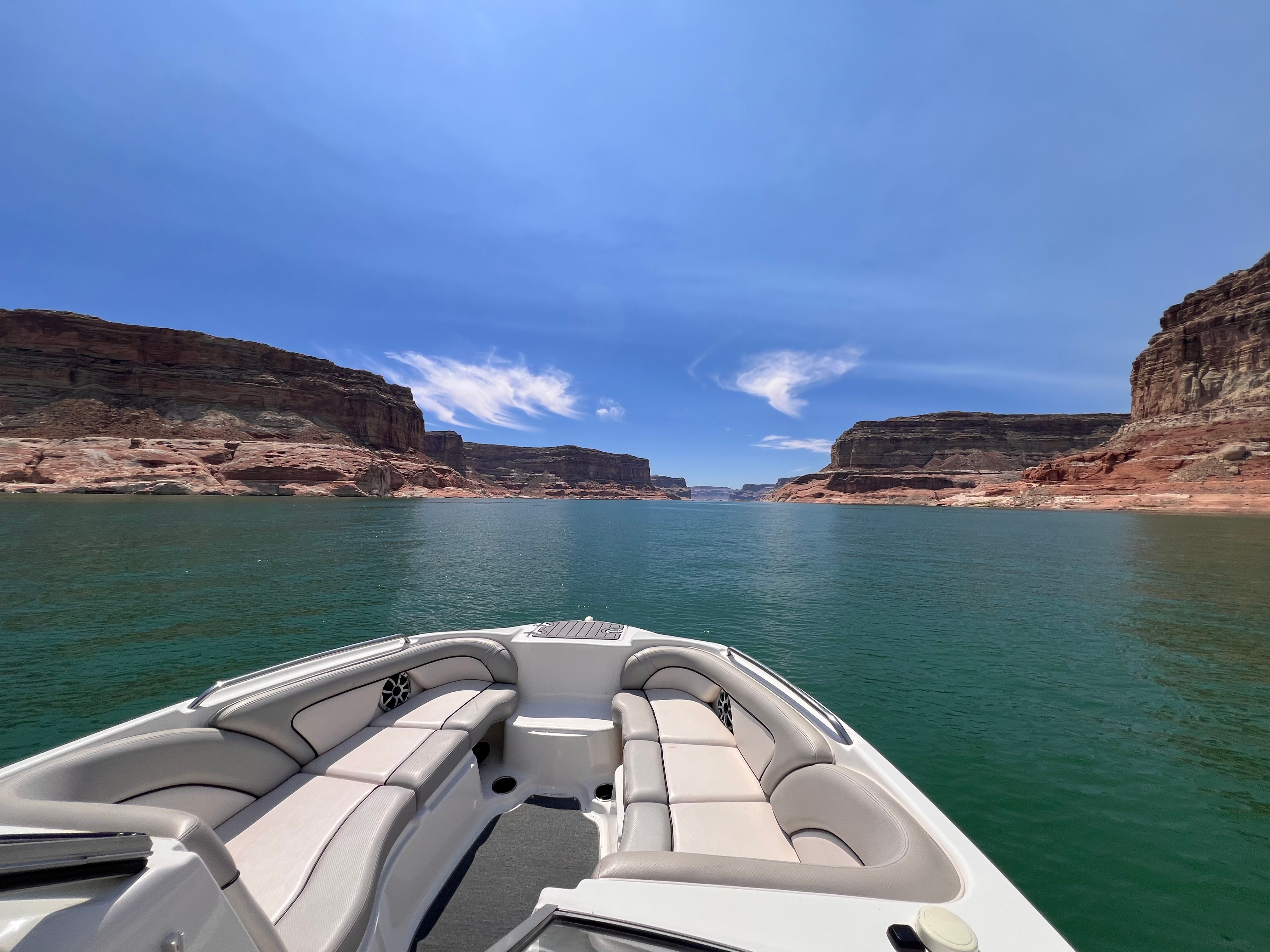 Yamaha AR240 HO boat on calm water between cliffs.