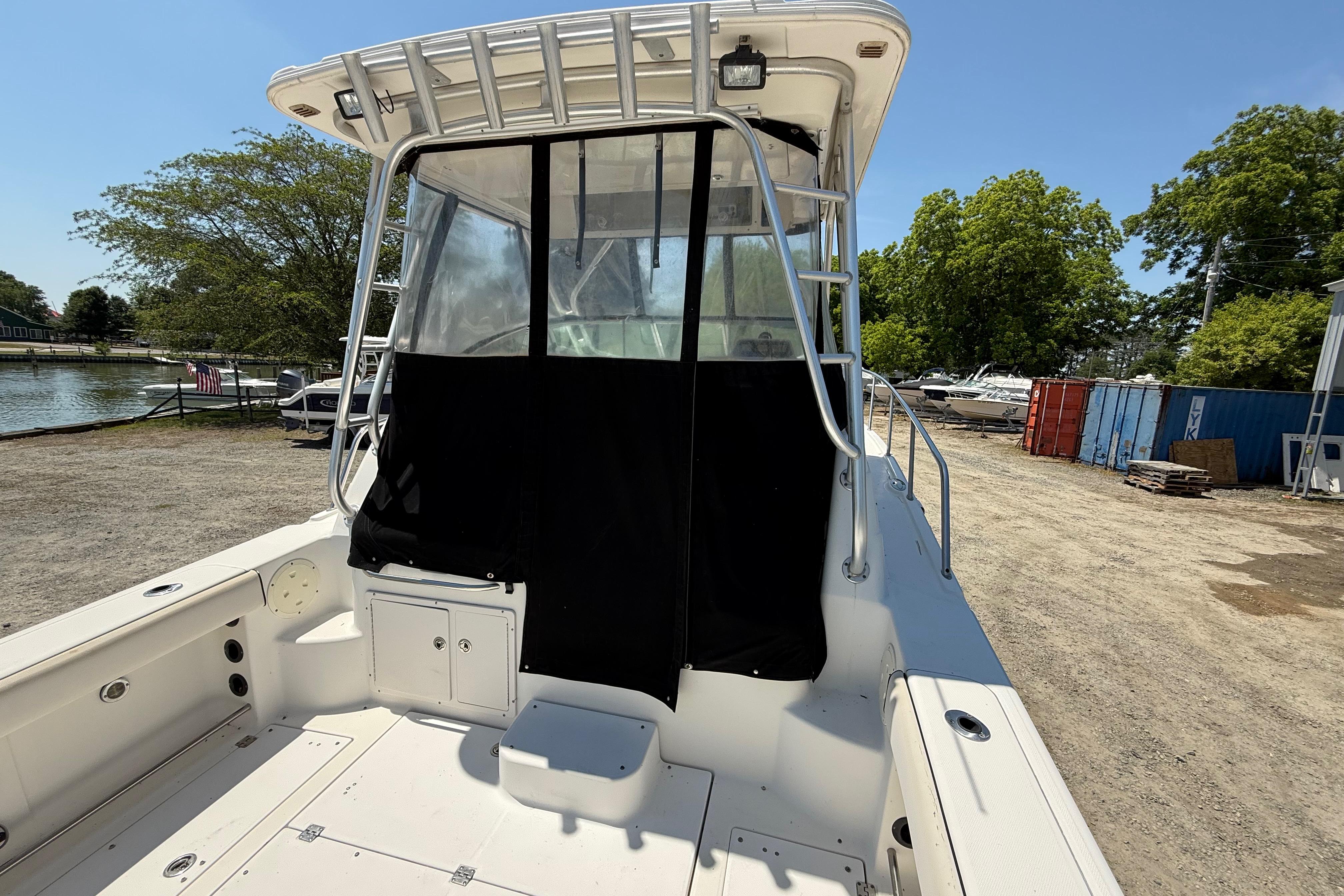 2007 Robalo R305 Walkaround boat with covered cockpit, docked near a marina.