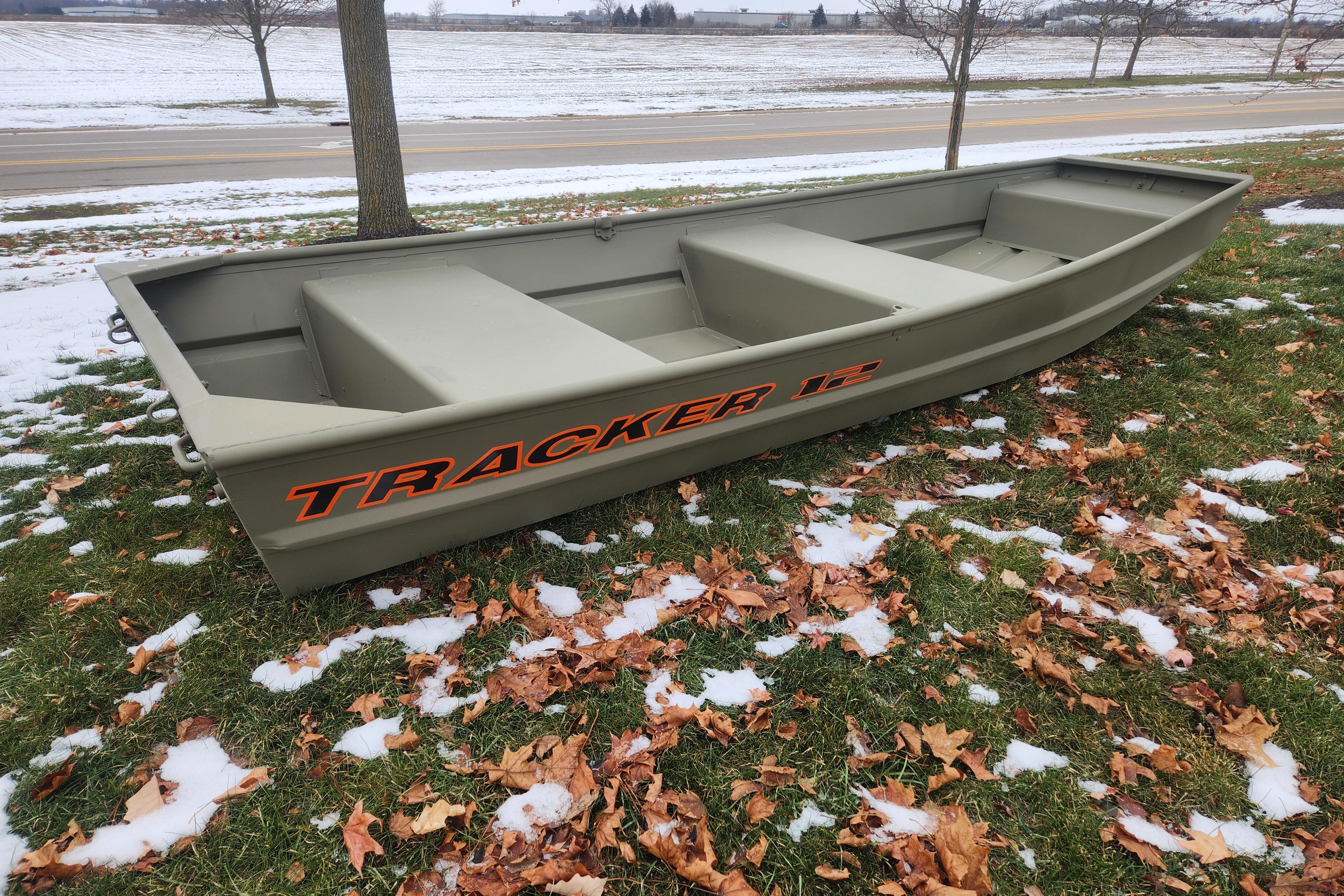 2026 Tracker Grizzly 12 Jon boat on snowy grass with autumn leaves.