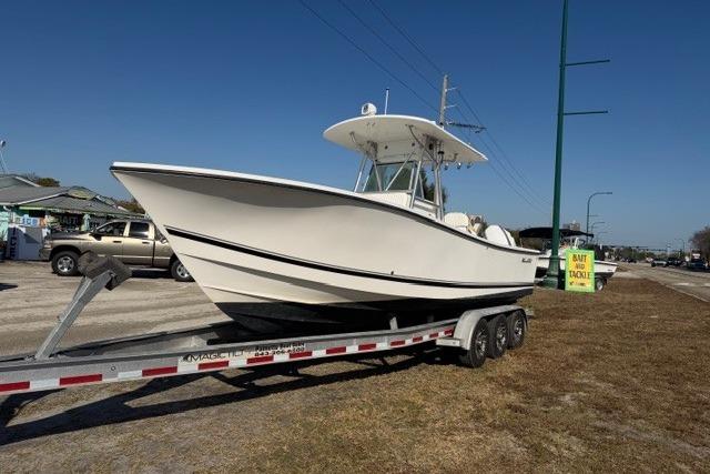2002 Regulator 26 Forward Seating boat on trailer, parked outdoors.