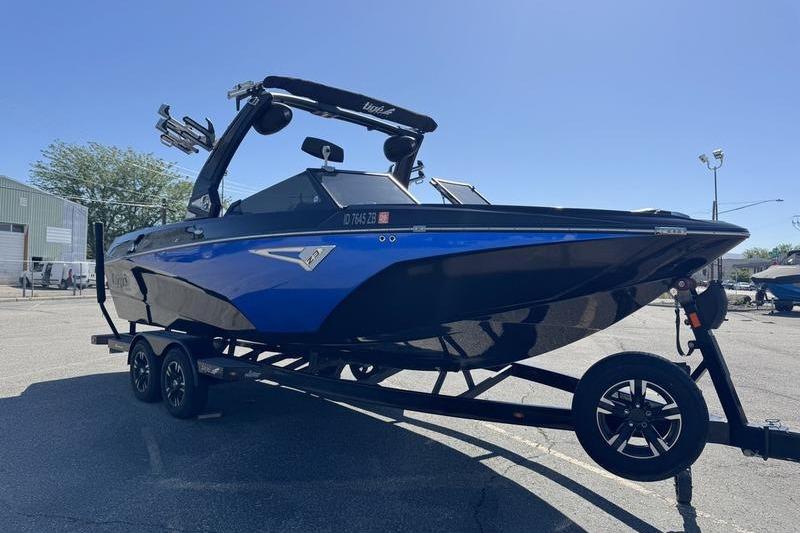 2022 Tigé Z3 boat on trailer, blue and black design, parked outdoors.