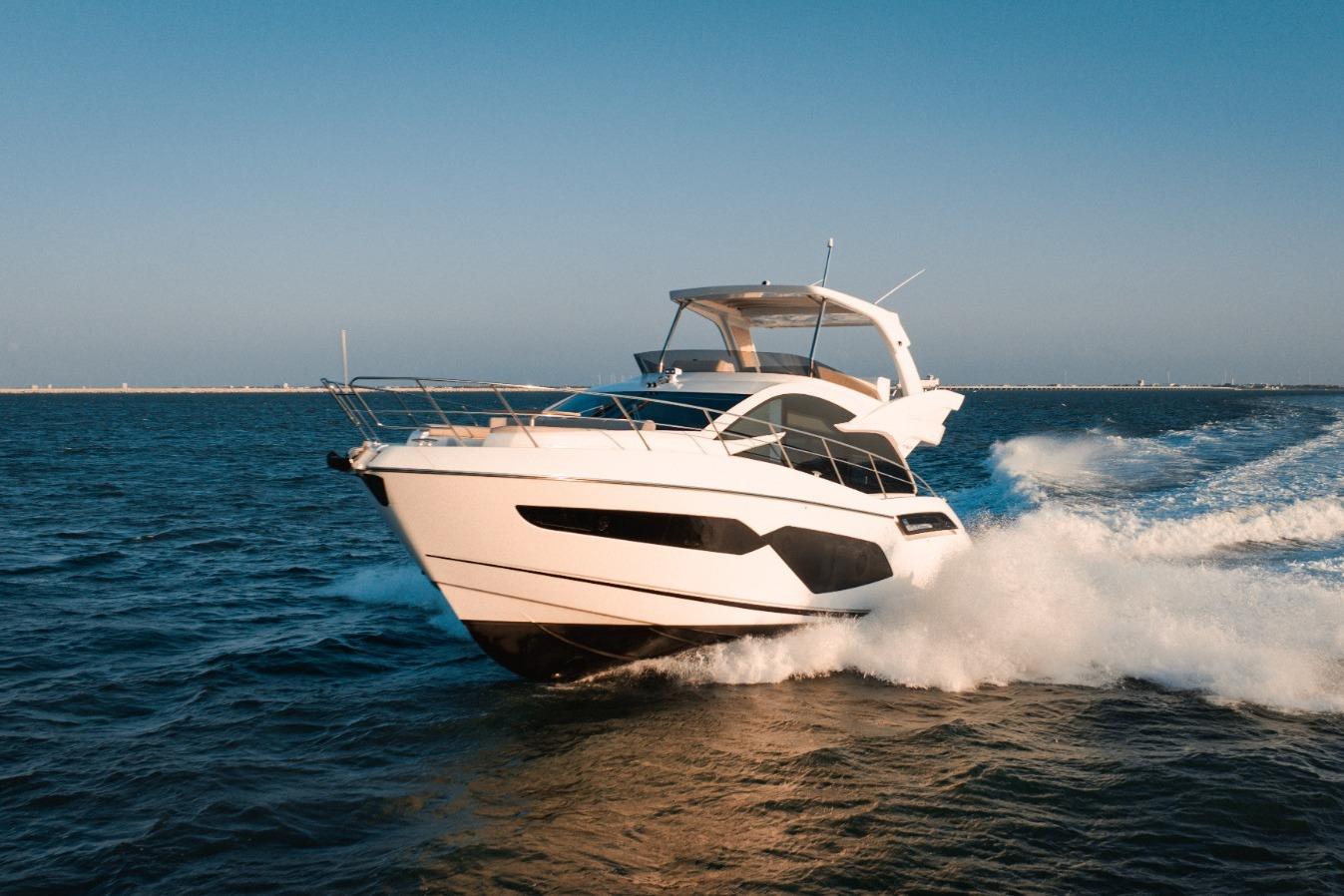 2024 Sunseeker Manhattan 55 yacht cruising on open water, showcasing sleek design and luxury.