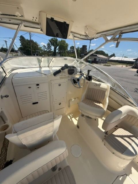 The image shows the cockpit of a 2004 Scout 242 Abaco boat with beige seating.