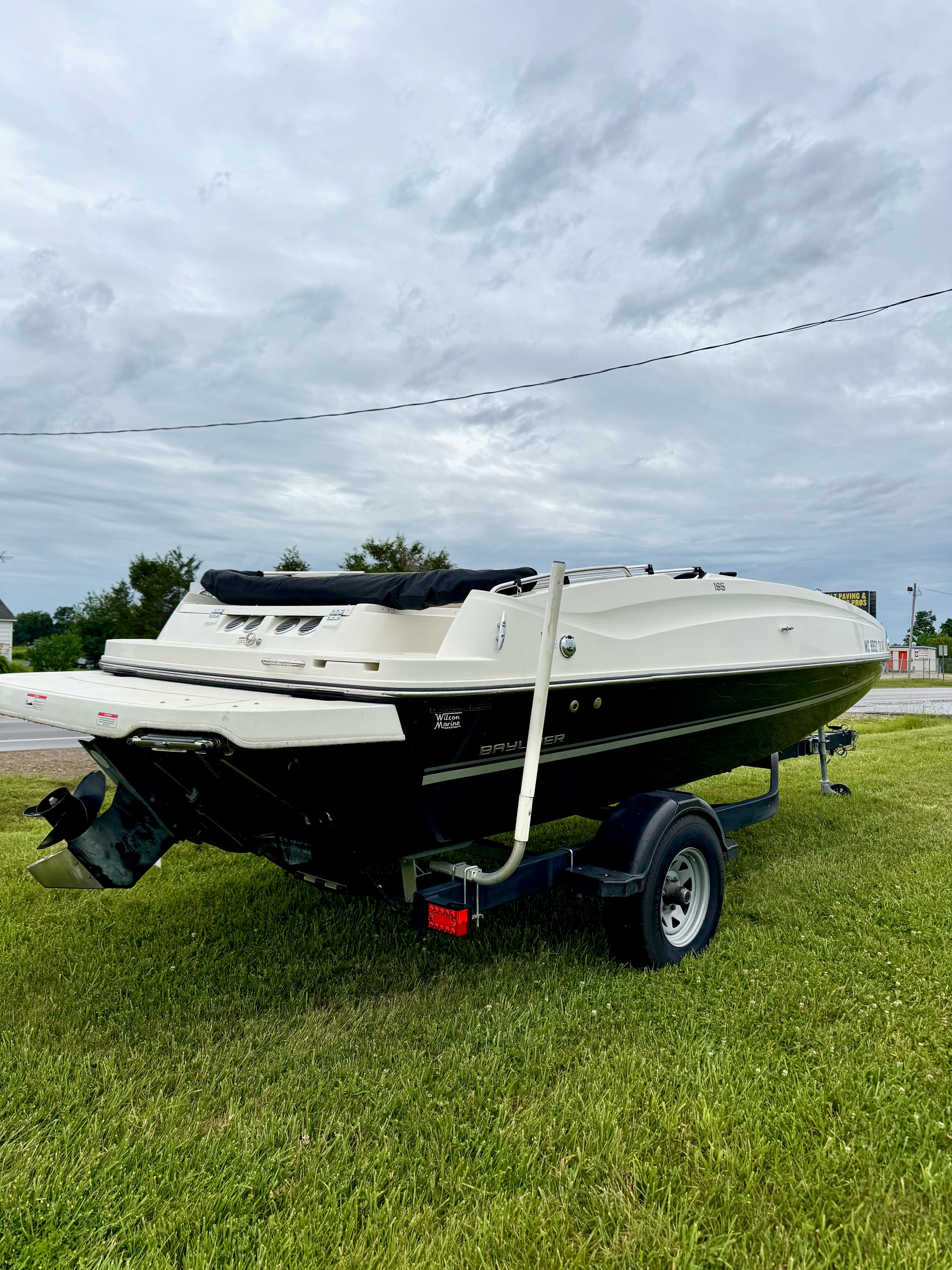 A 2017 Bayliner Element E18 on a trailer, parked on grass.