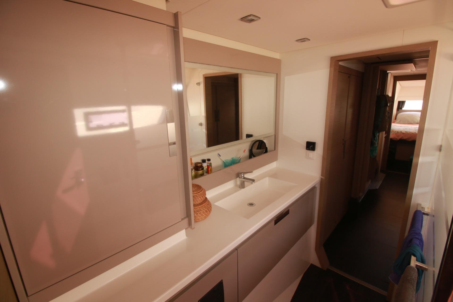 Modern bathroom interior of 2022 Fountaine Pajot Elba 45 Catamaran, featuring sleek cabinetry and spacious design.