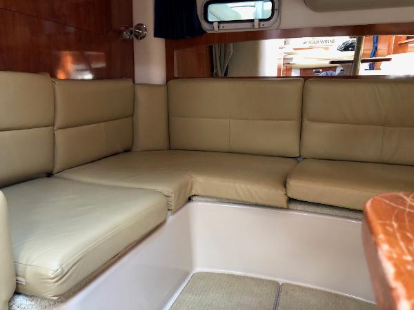Interior of the 2008 Four Winns V338 with beige upholstery and wood accents.
