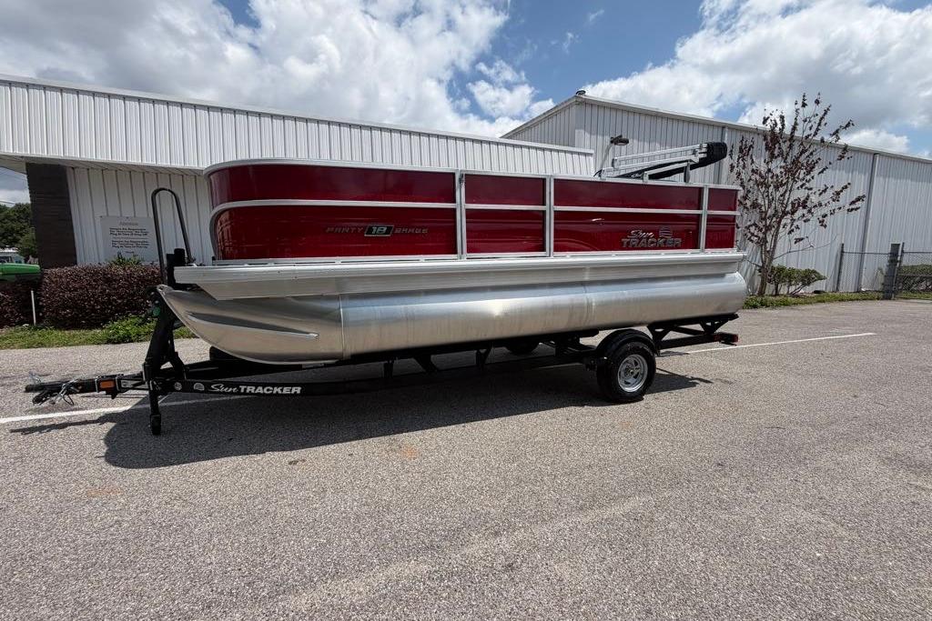 2026 Sun Tracker Party Barge 18 DLX pontoon boat on trailer, parked outdoors.