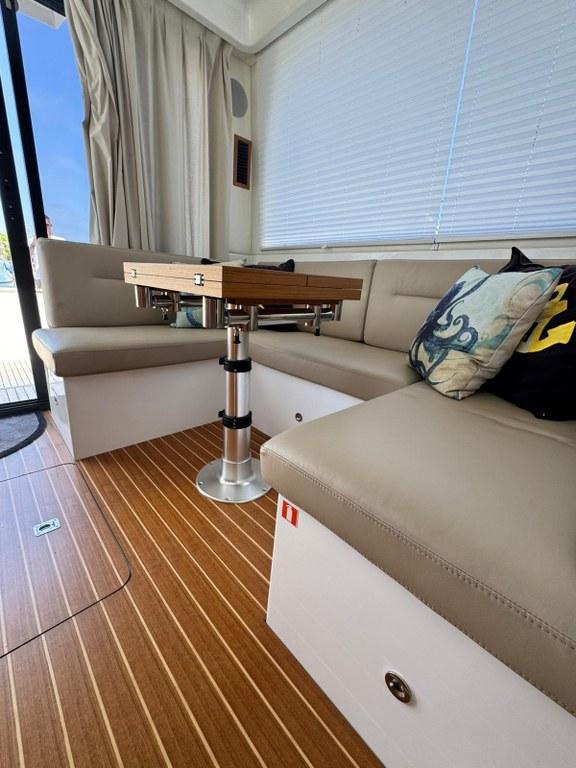 Luxurious interior of 2022 Rodman 1290 Evolution yacht with elegant seating and wooden flooring.