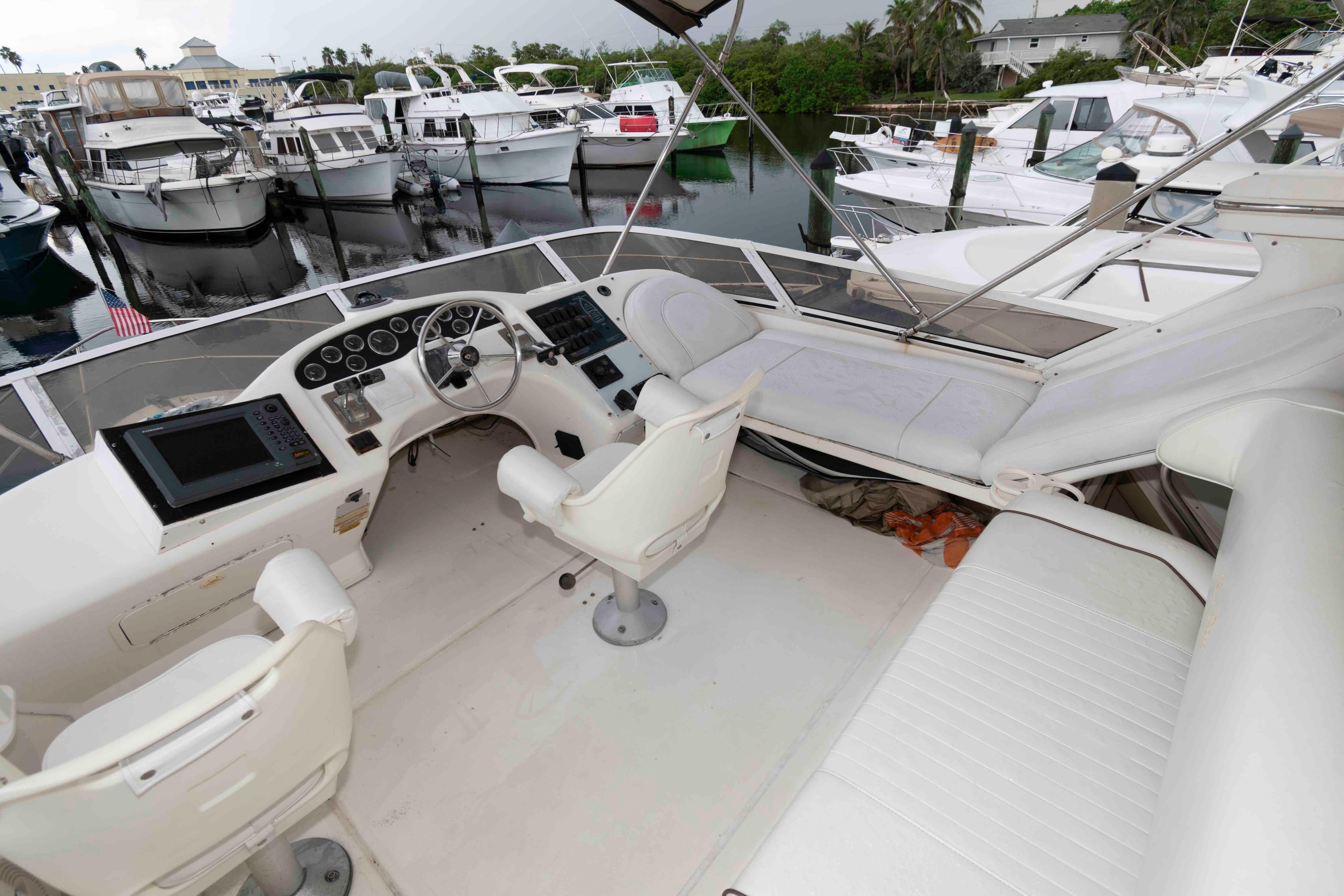 1998 Sea Ray 370 Aft Cabin yacht interior with helm, seating, and marina view.