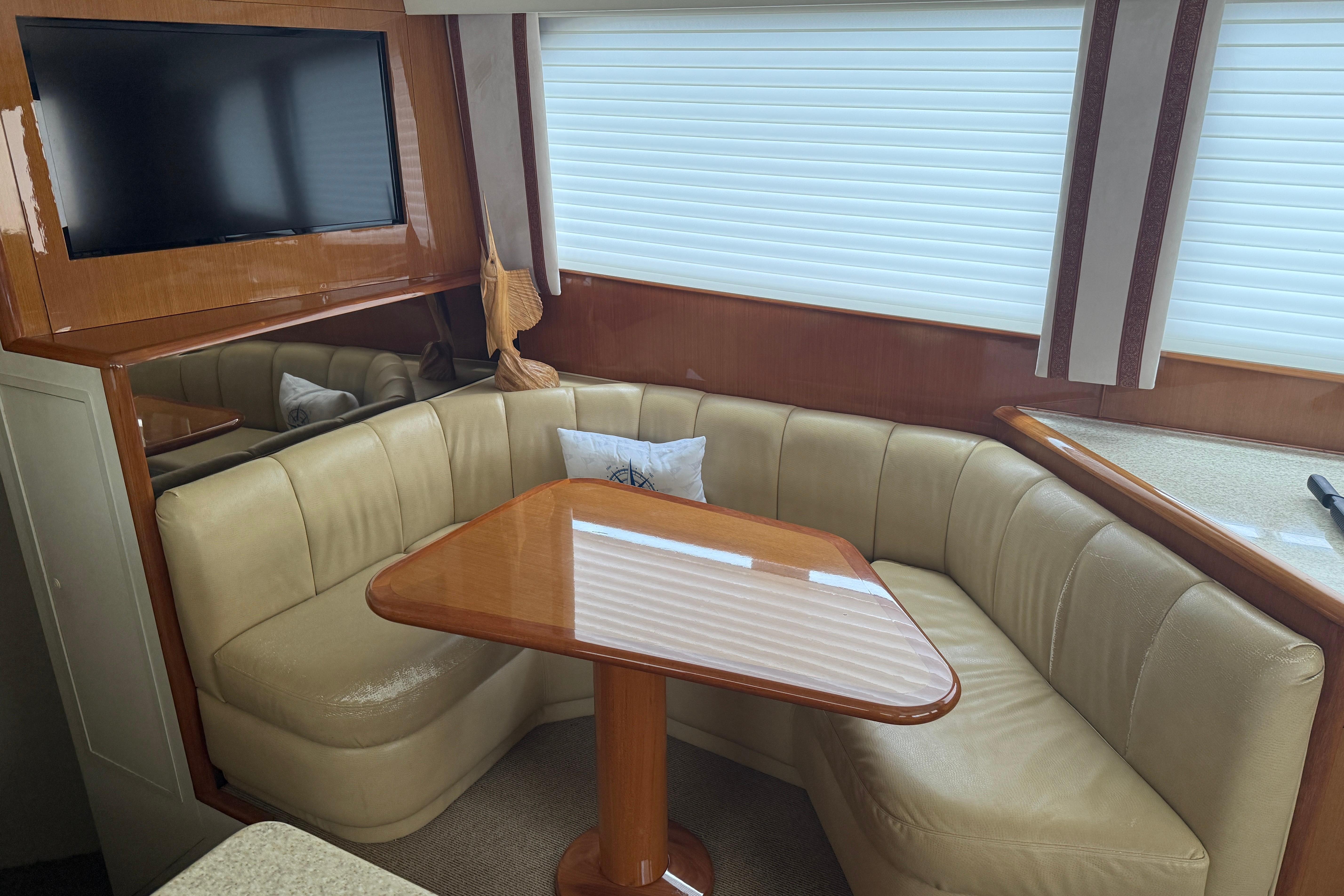 Interior of 2000 Viking 55 Convertible yacht with leather seating and wooden table.