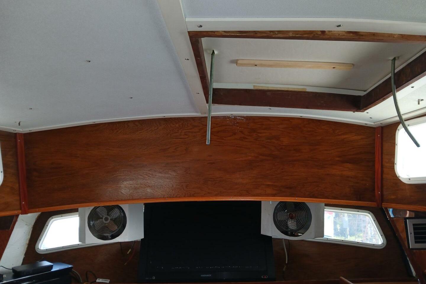 Interior of a 1976 Islander Freeport boat with wood paneling and fans.