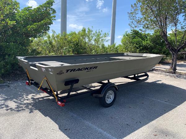 2025 Tracker GRIZZLY 2072 Utility boat on trailer in sunny parking lot.