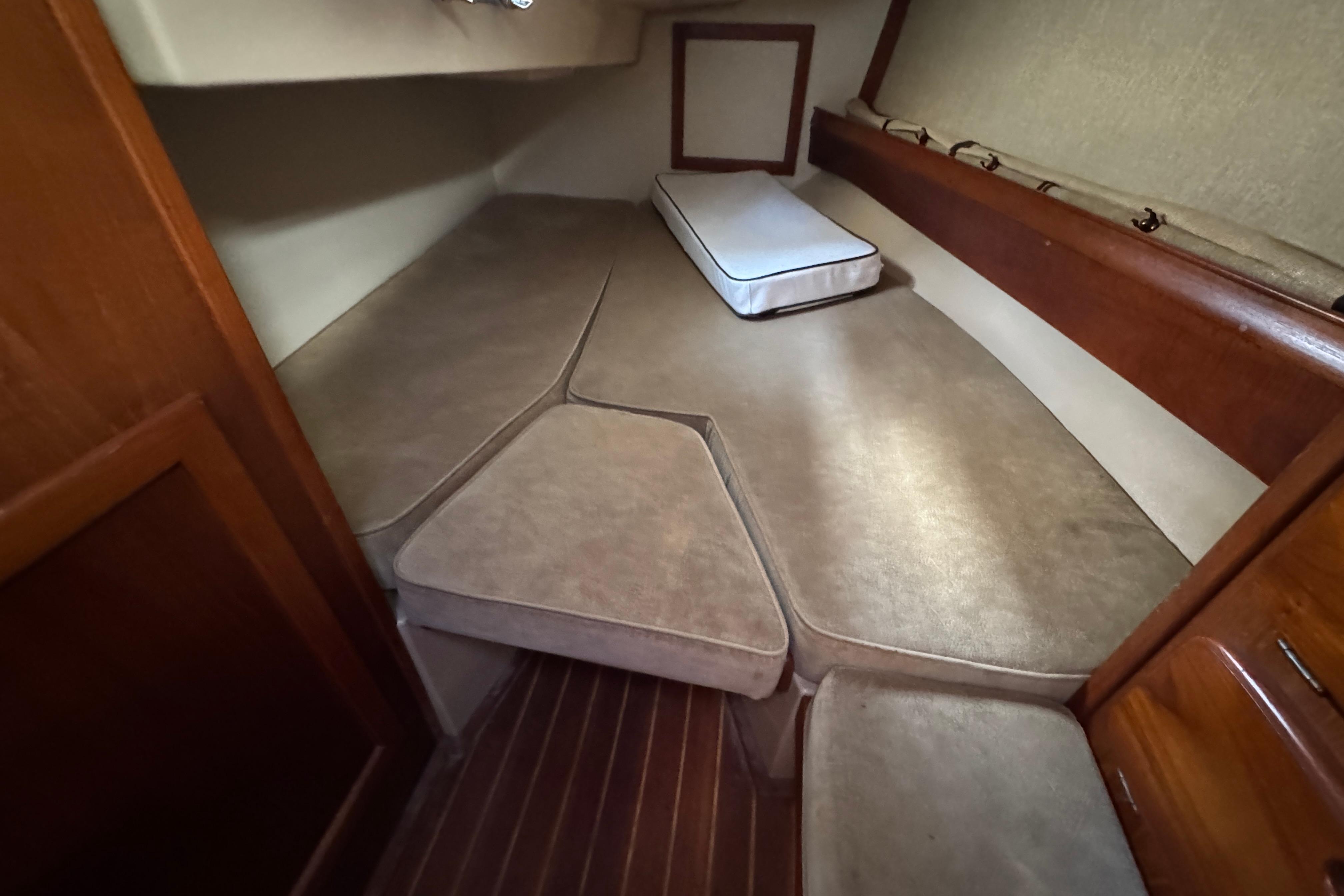 Interior cabin of 1991 Island Packet Yachts 38, featuring cushioned seating and wooden accents.
