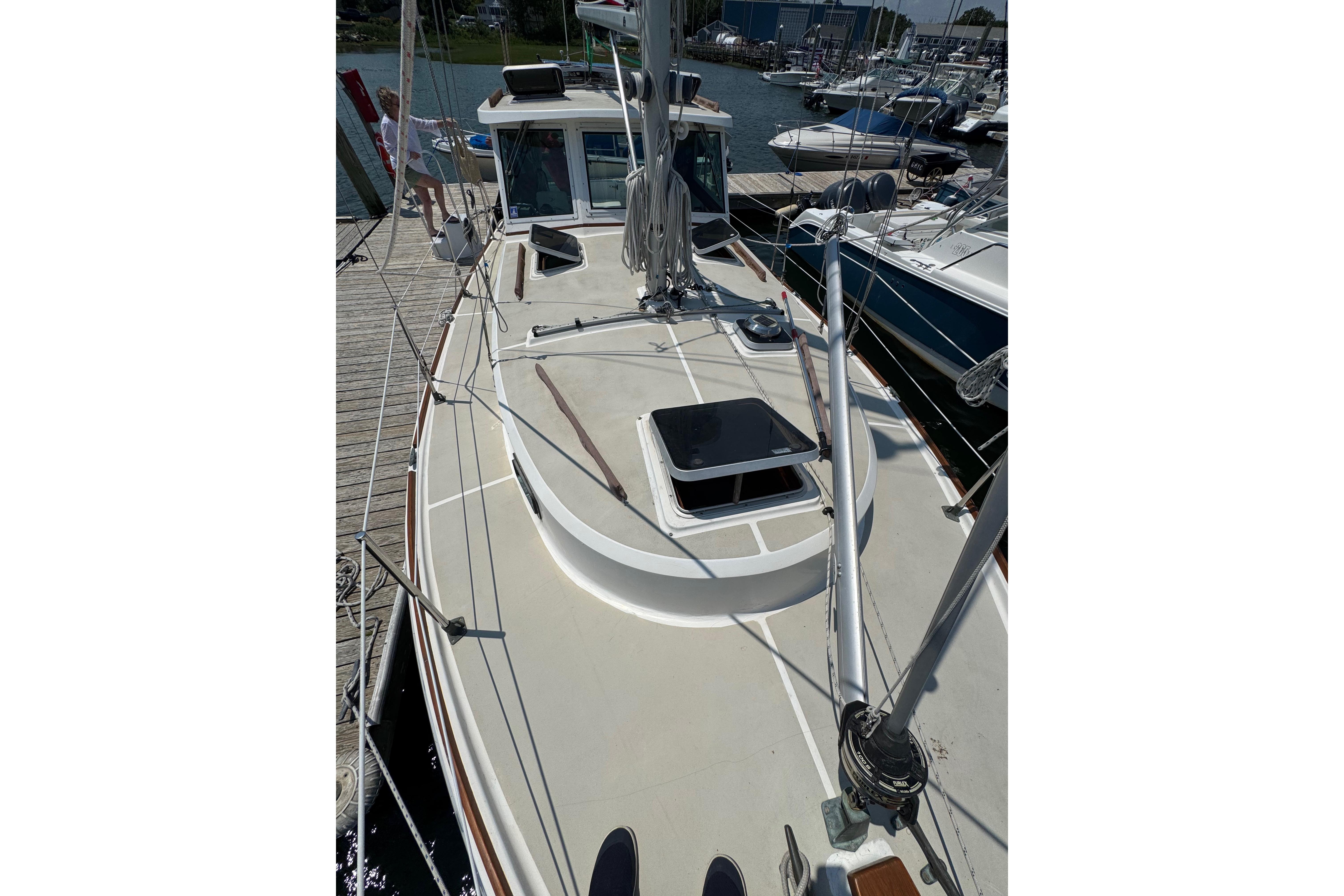 1989 Cape Dory 30 Motorsailer docked, showcasing deck and rigging details.