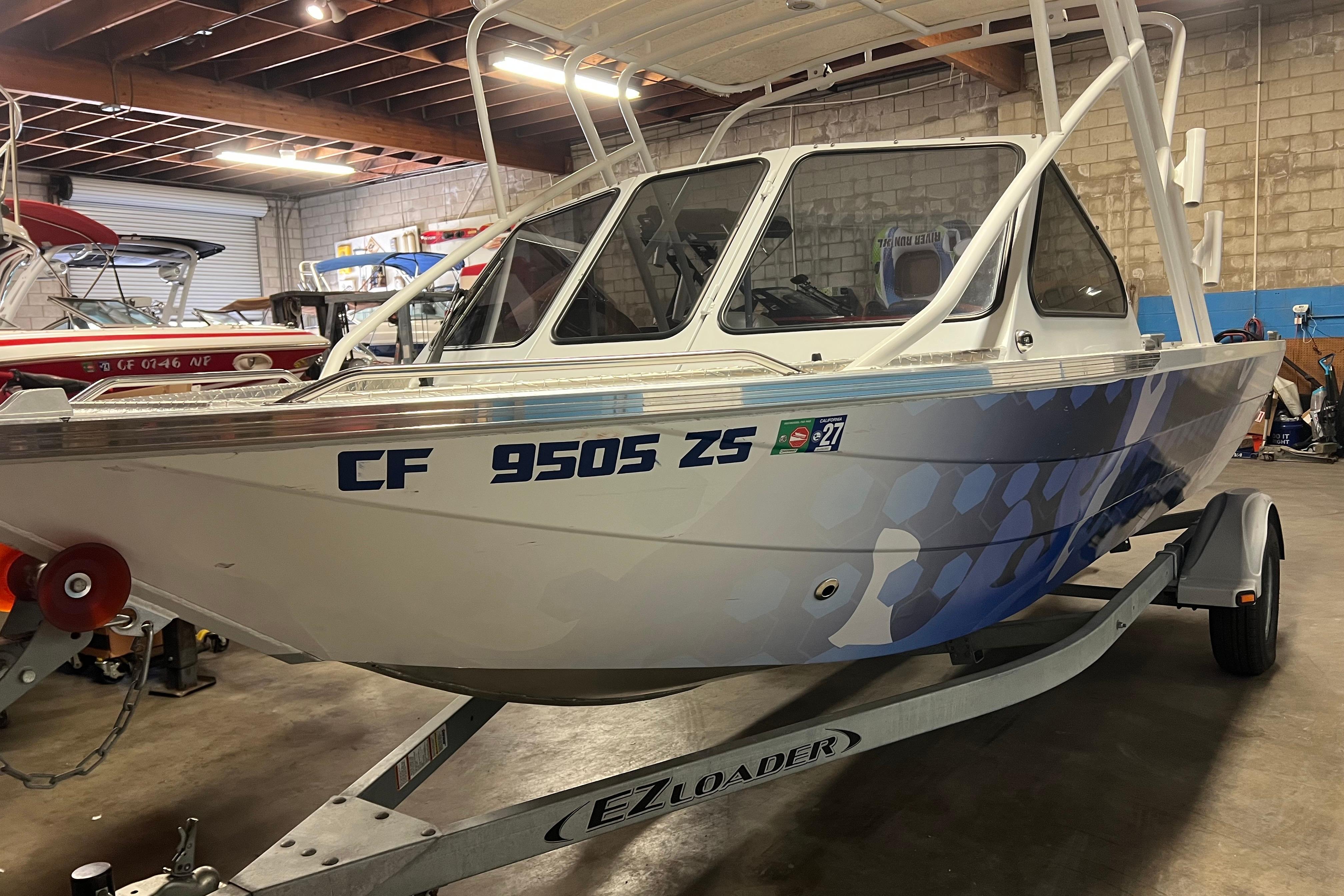 2019 KingFisher 1825 Falcon boat on EZ Loader trailer in a garage setting.