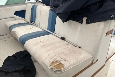 Worn seating on 1989 Sea Ray 300 Sundancer boat with visible damage and blue accents.
