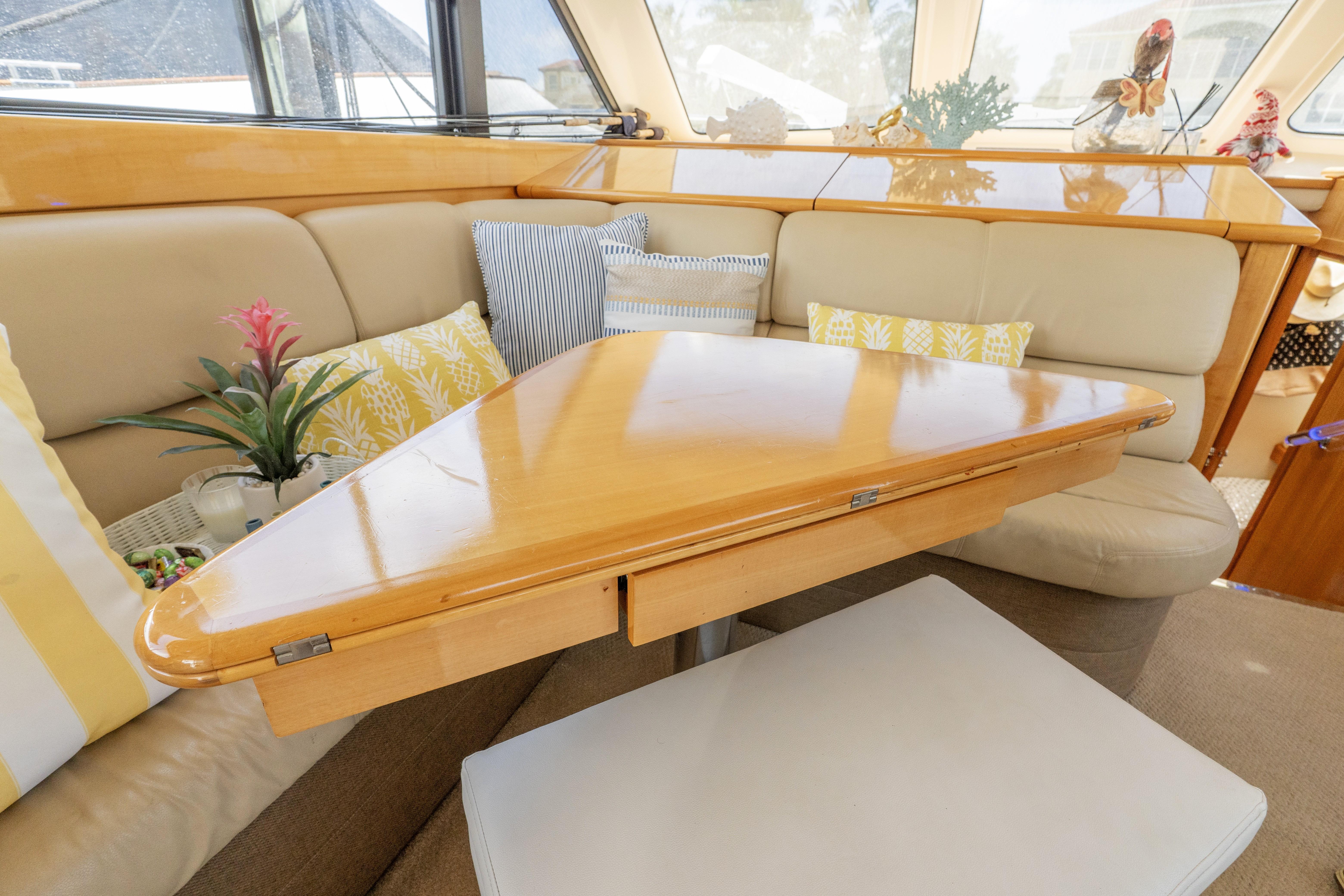 Luxurious interior of 2008 Maritimo 52 yacht with wooden table and plush seating.