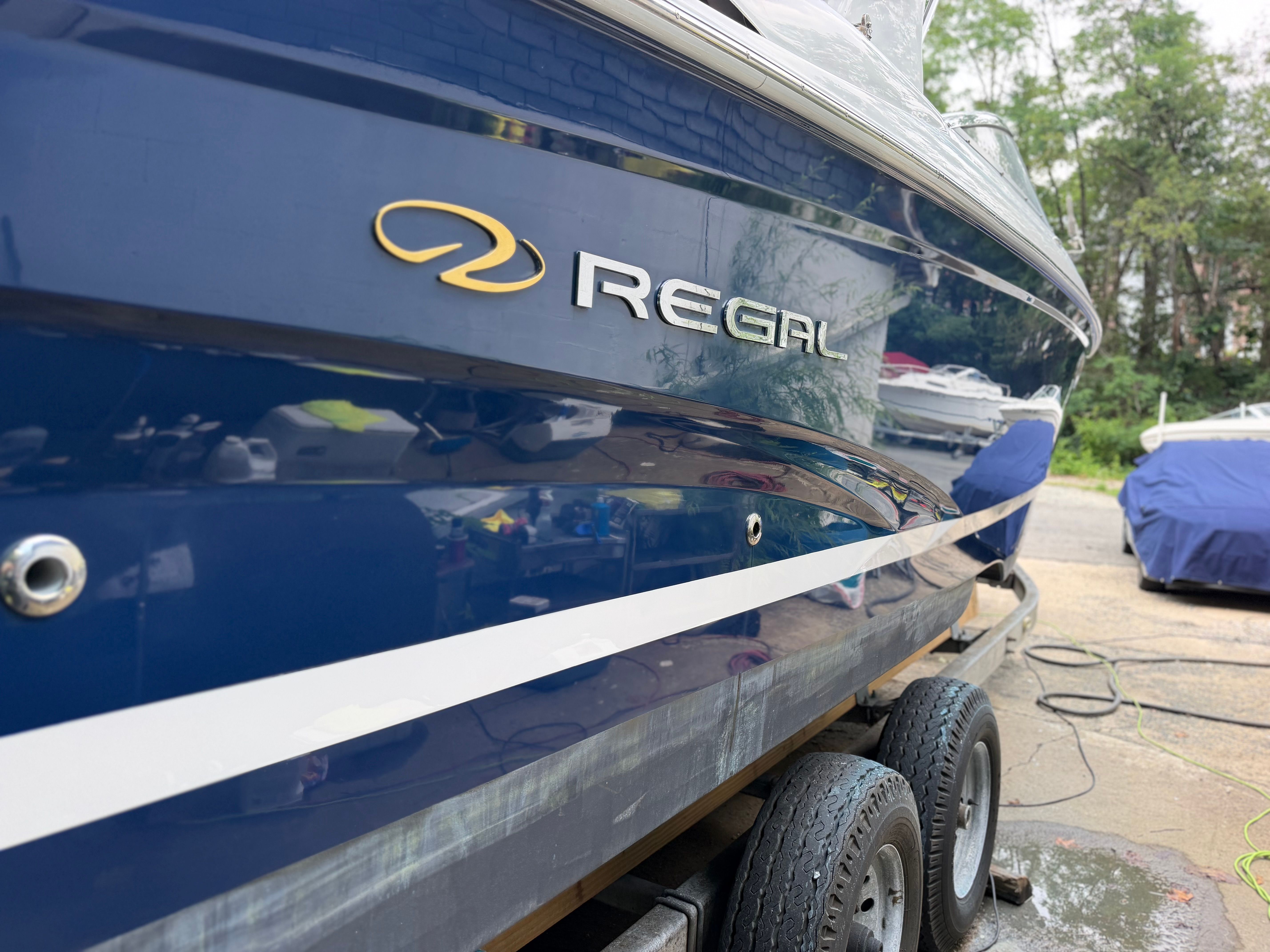 A 2011 Regal 2750 Cuddy boat on a trailer. It features a blue hull.