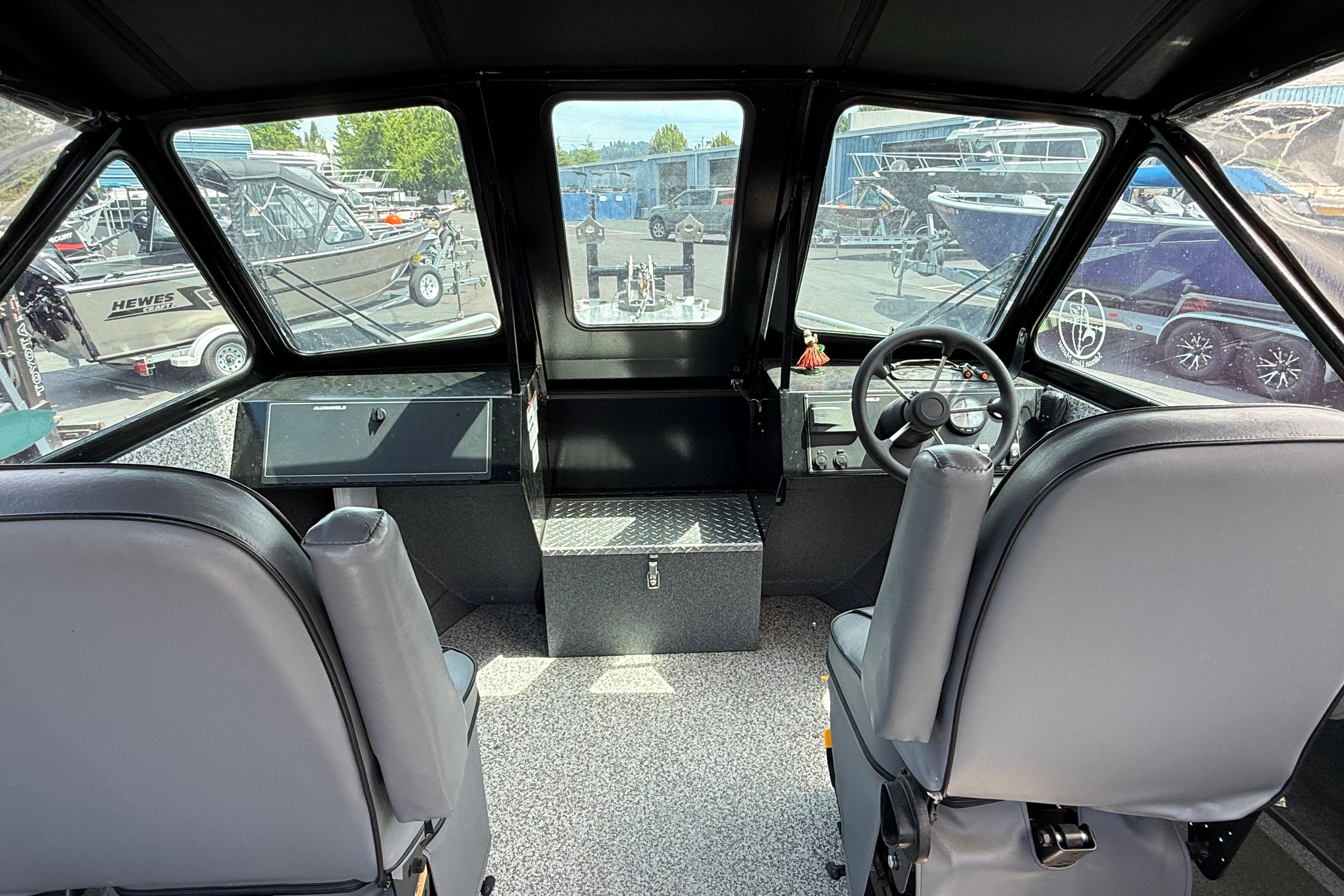 Interior of 2019 Alumaweld Intruder Hard Top 22' boat with steering wheel and seats.