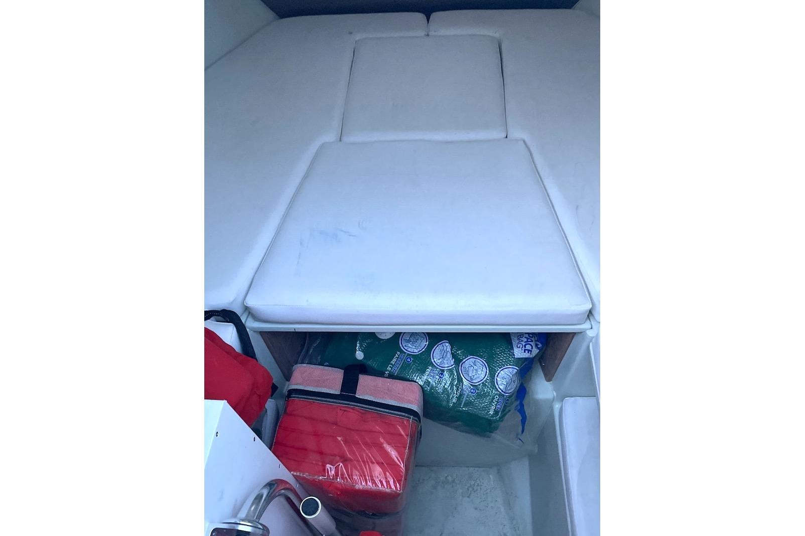 Interior cabin of 2002 Intrepid 323 Cuddy with storage and cushions.
