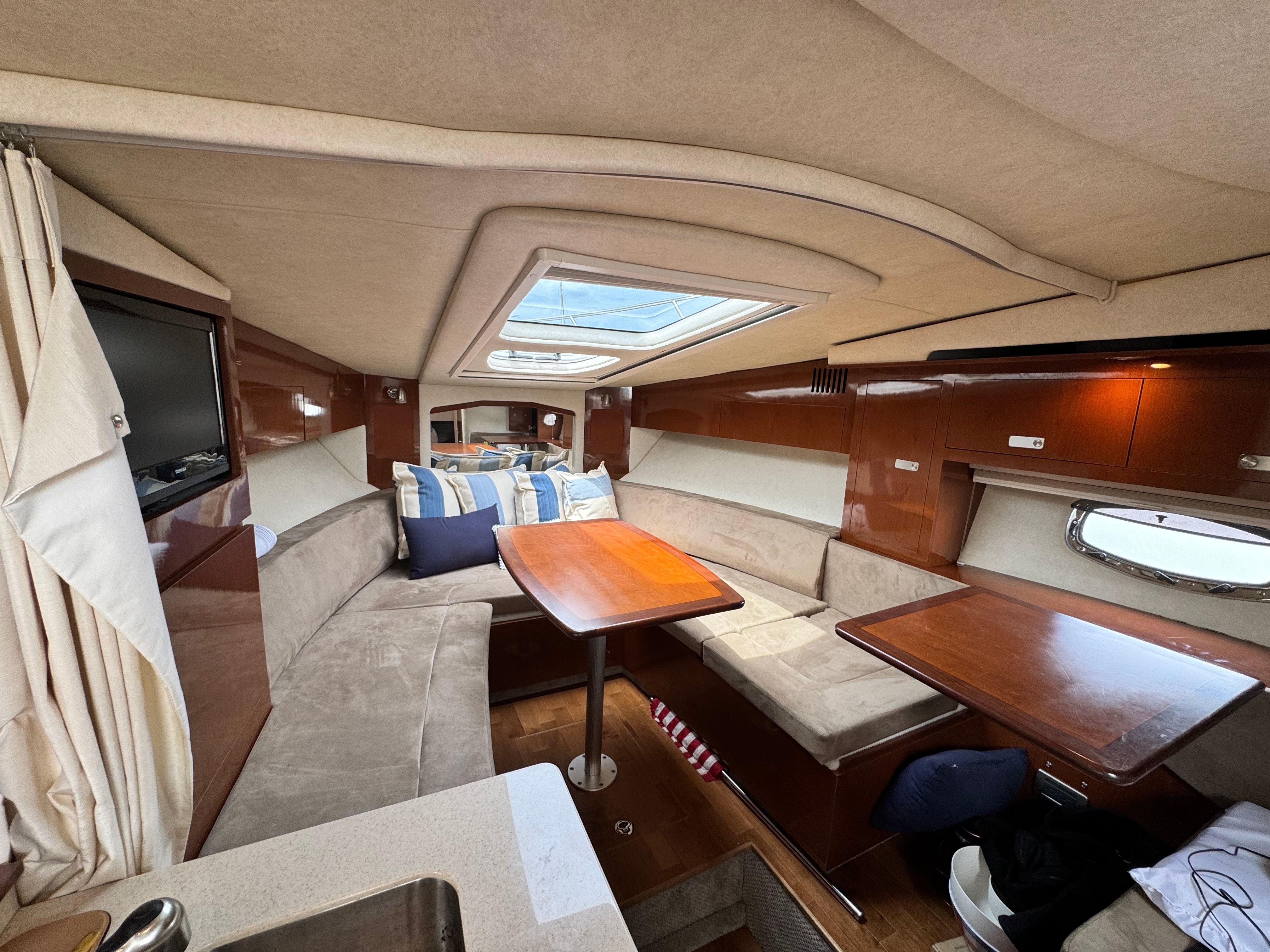 Interior of a Sea Ray Sundancer 310 with cozy seating area and wooden table.