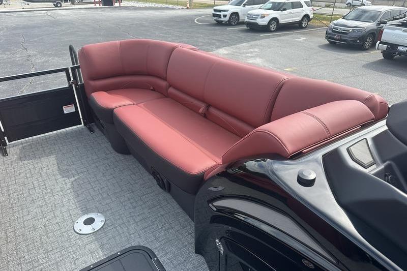 2026 Regency 230 DL boat with red seating and gray flooring in a parking lot.