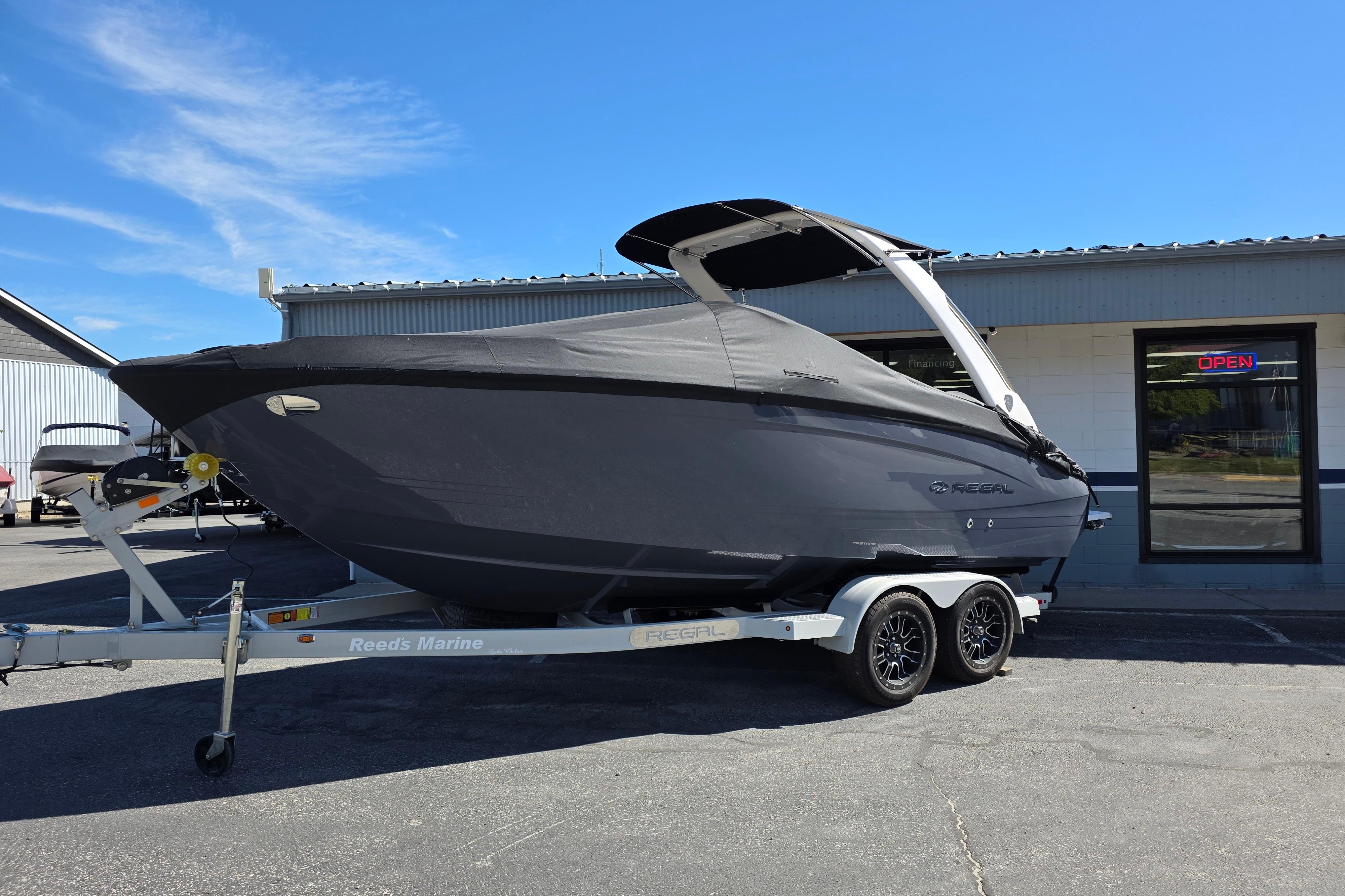 2026 Regal LS4 boat on trailer outside a marine dealership under clear blue sky.