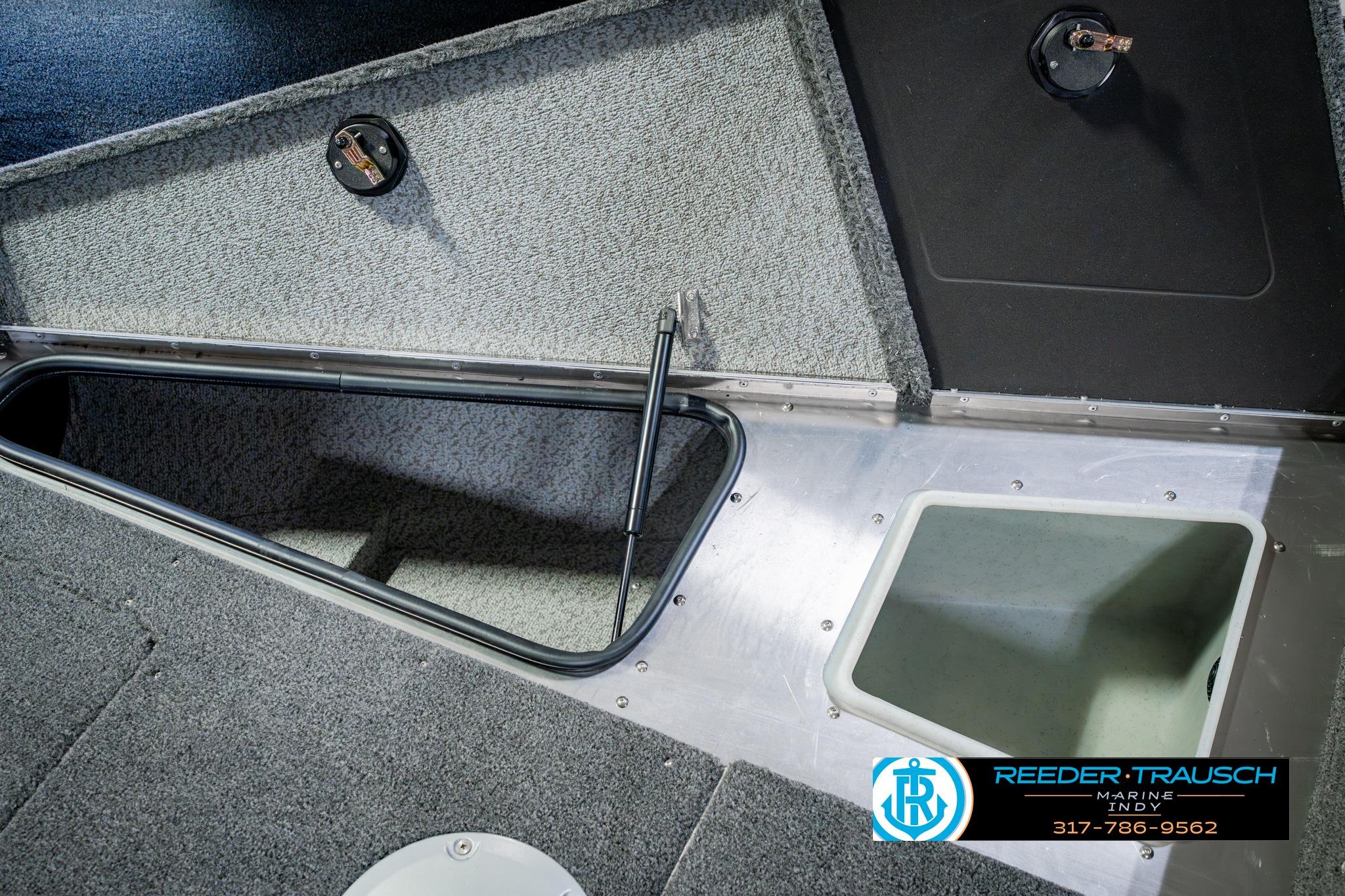 2026 Lund 1875 Impact XS boat storage compartments with carpeted interior and open hatches.