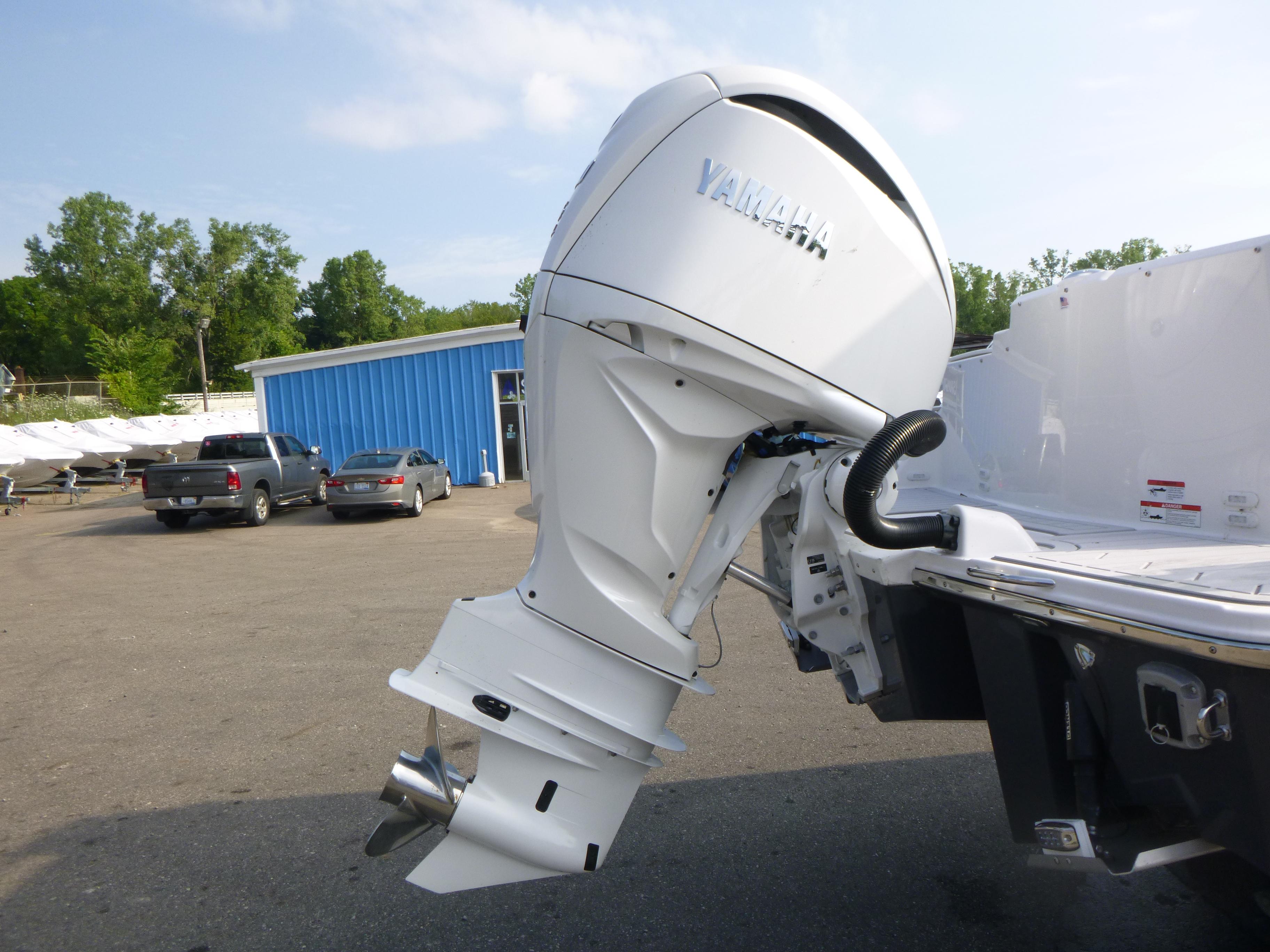 Outboard motor on a Solara S-250 CW boat, 2025 model, in a marina setting.