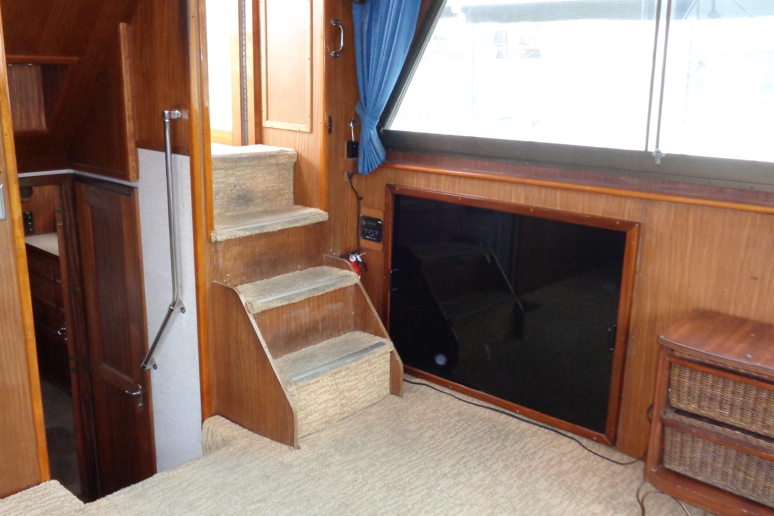Interior of 1981 Hatteras 48 Cockpit Motor Yacht with carpeted stairs and wood paneling.