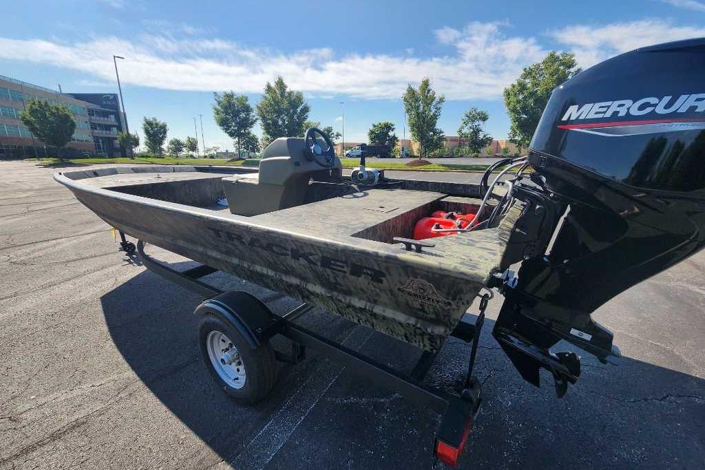 2026 Tracker Grizzly 1648 SC boat with Mercury engine in parking lot.