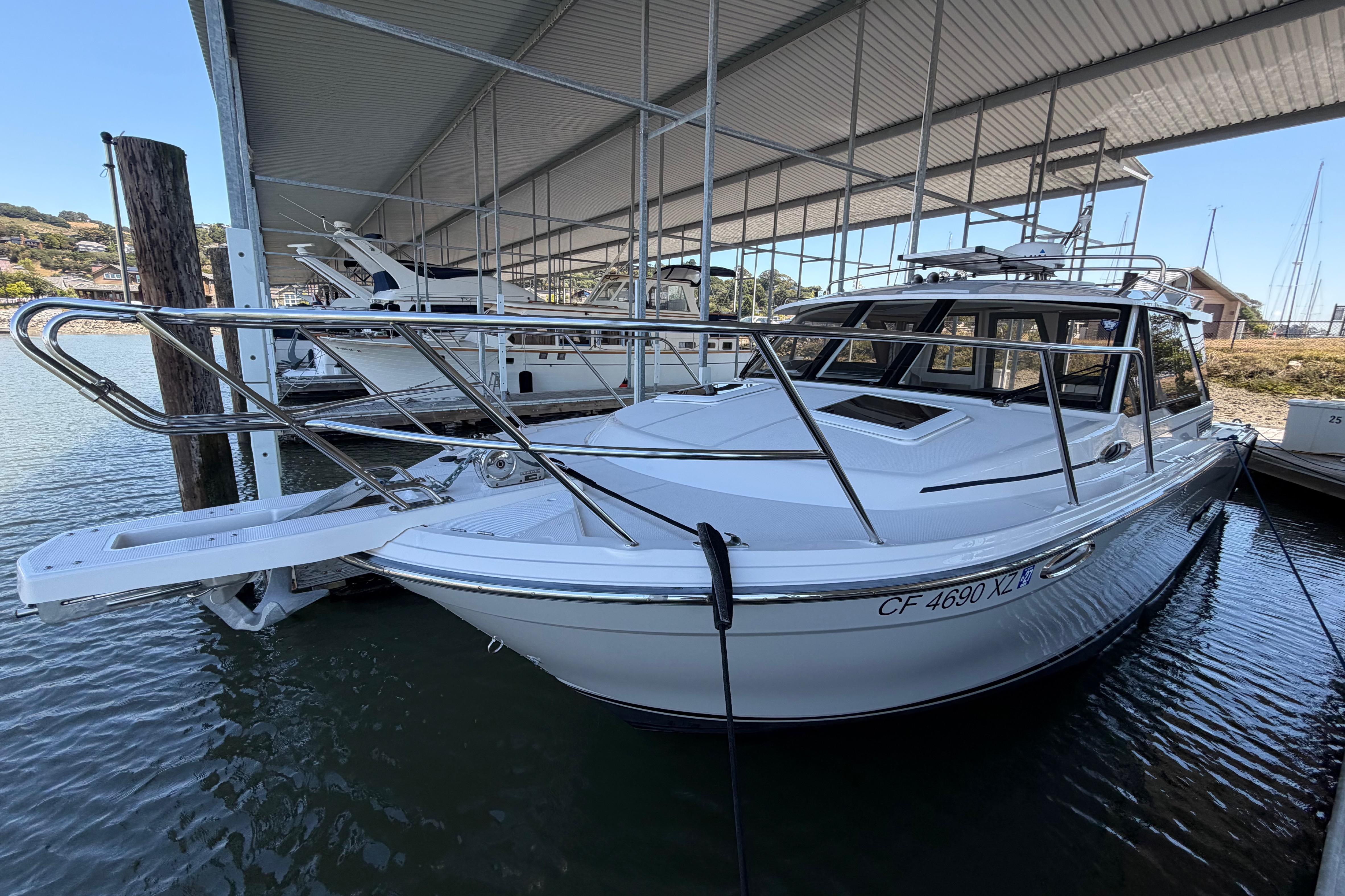 2023 Cutwater C-288 Coupe docked under a covered marina, showcasing sleek design and modern features.