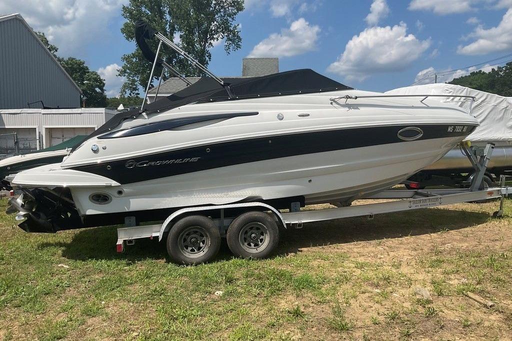 2015 Crownline 236 SC boat on trailer, parked outdoors under a partly cloudy sky.