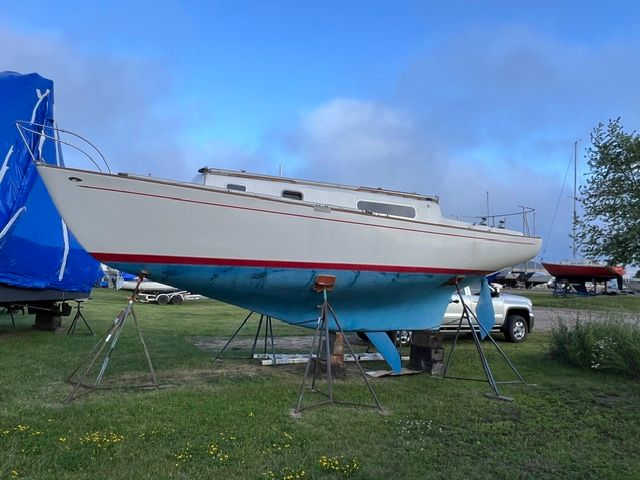 A 1969 Morgan 30 sailboat is on a stand on land.