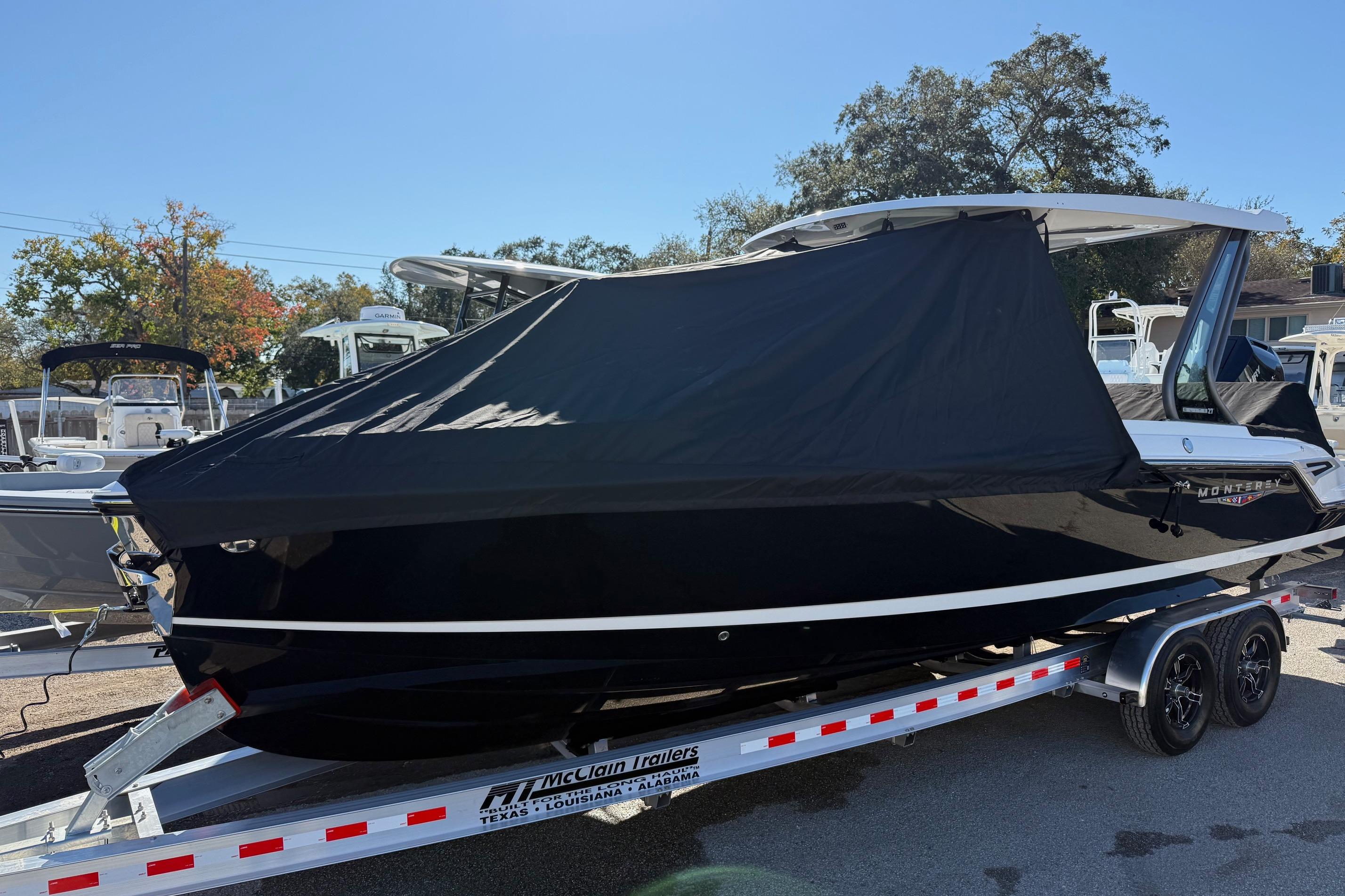 2026 Monterey Elite 27 OB boat with cover on trailer.