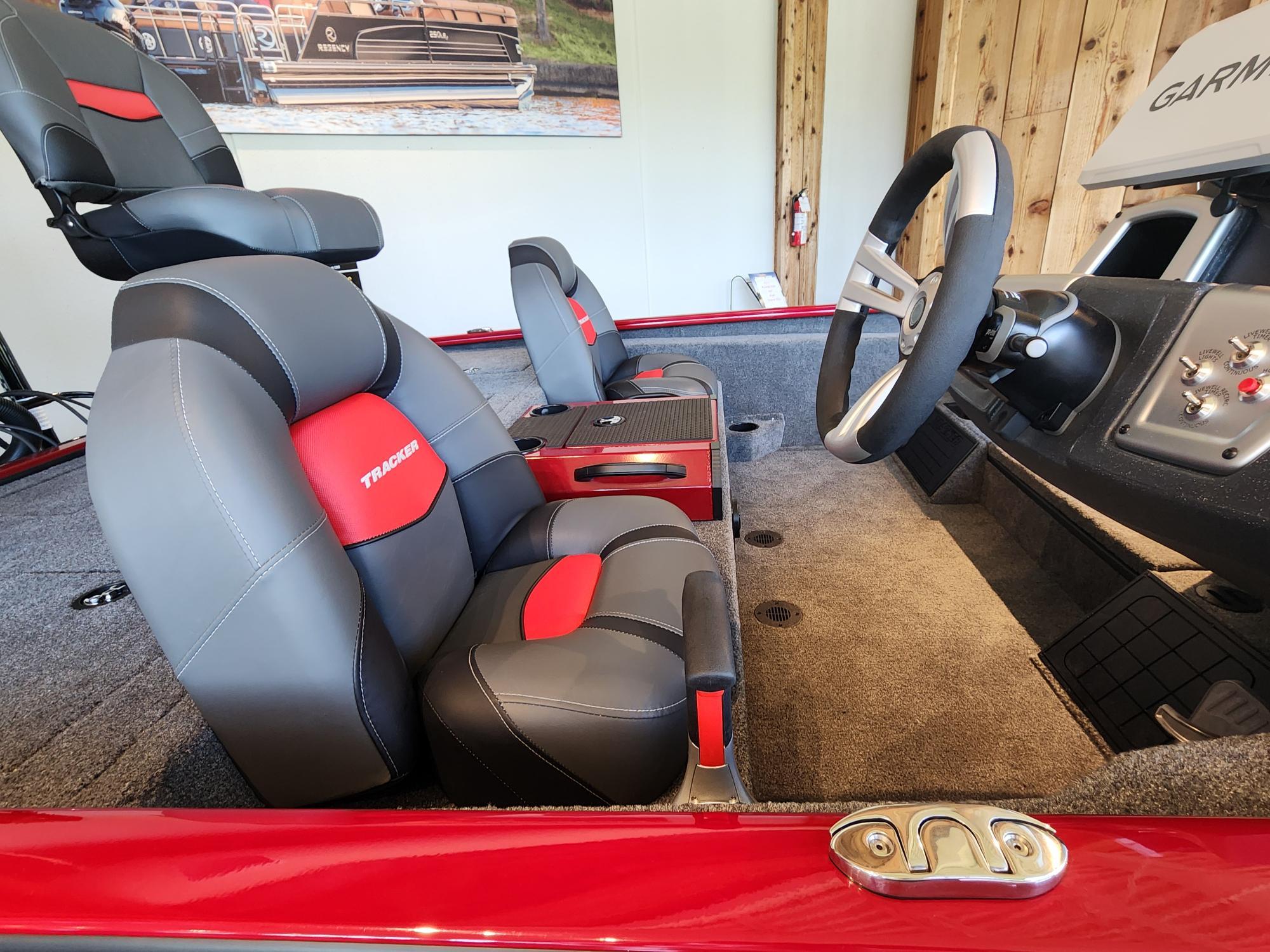 2025 Tracker Savage 215 boat interior with red and gray seating, steering wheel, and control panel.