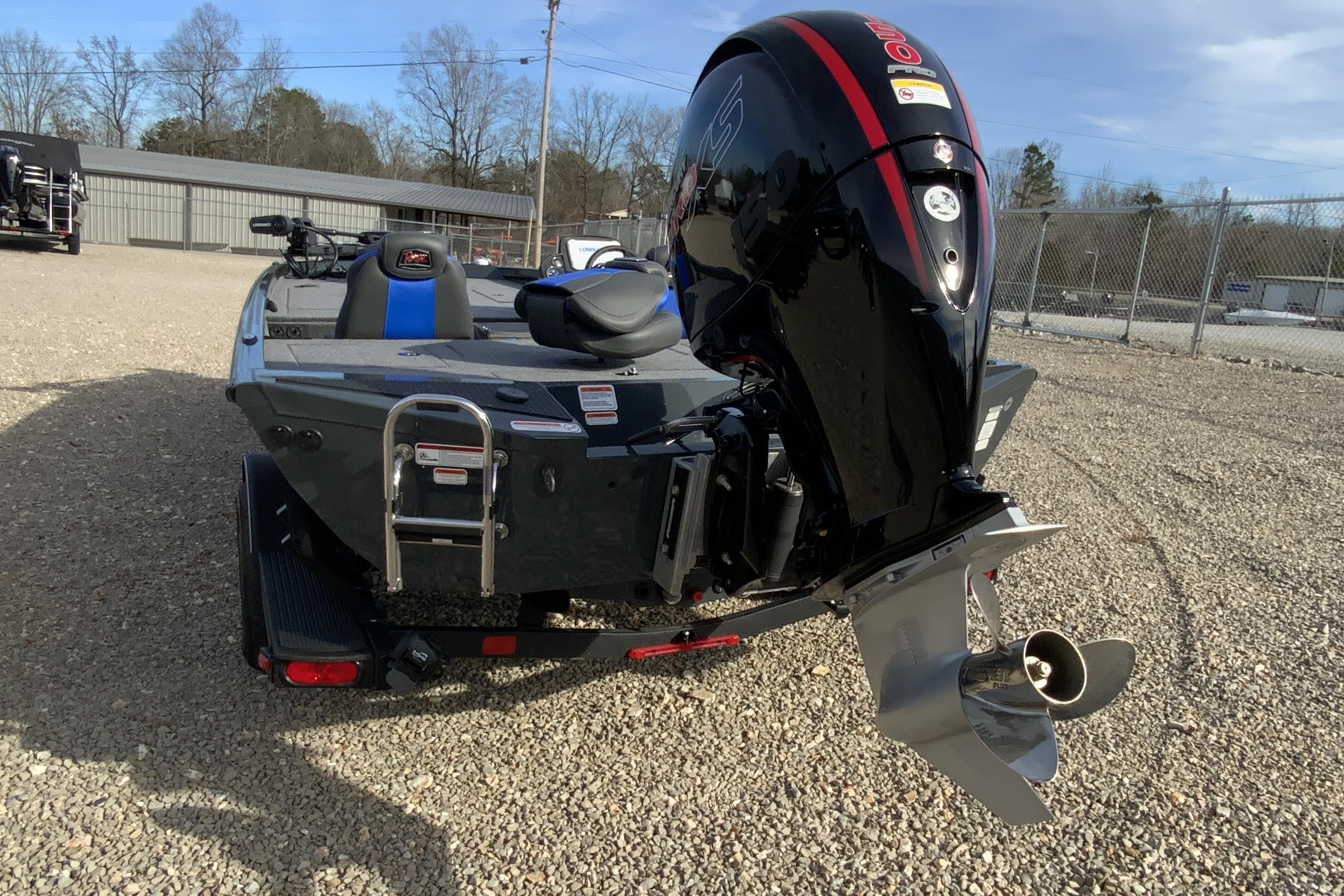 2026 Ranger RT198P boat with powerful outboard motor, parked on gravel lot.