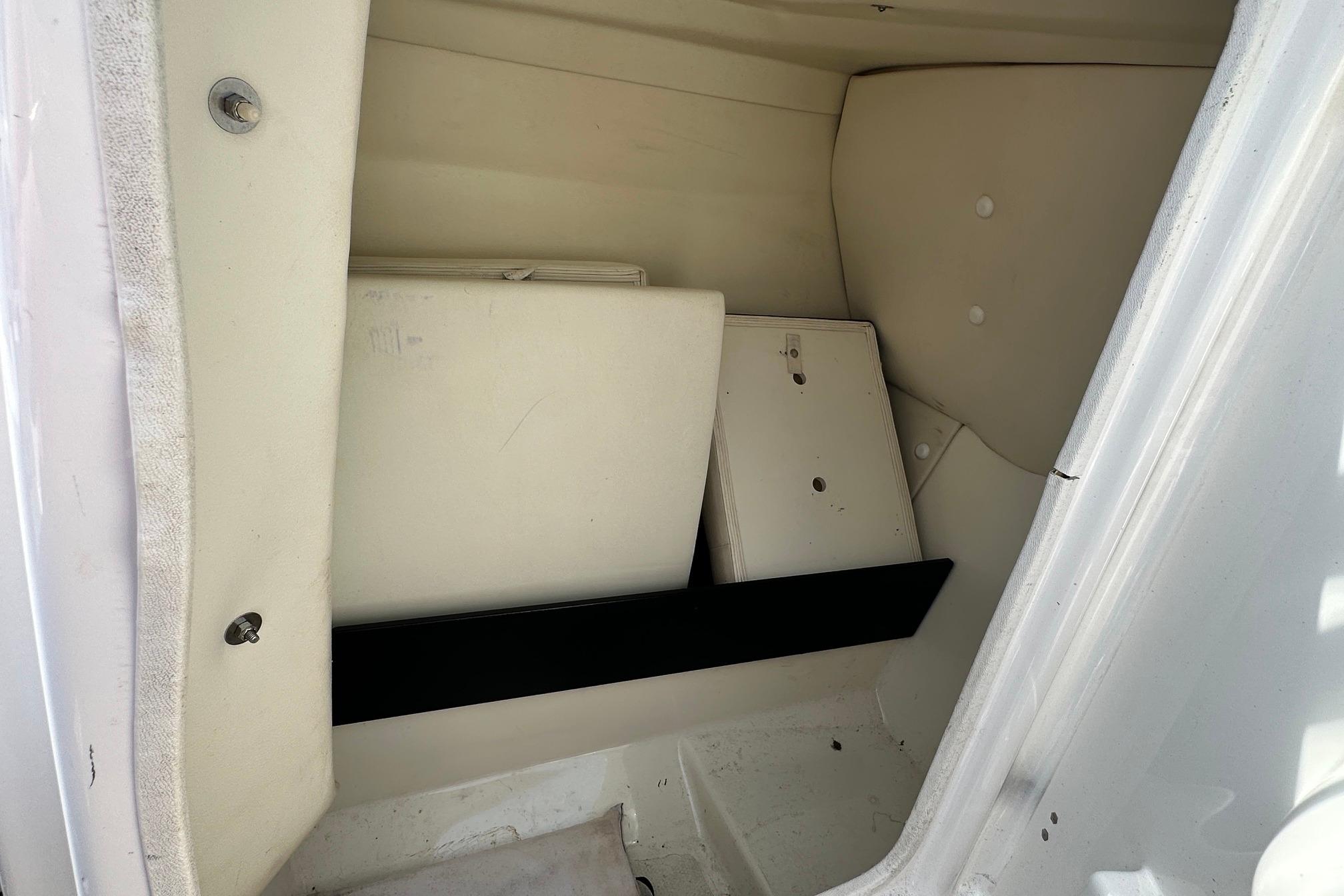 Storage compartment of a 2016 Yamaha 242 Limited S boat, featuring white interior panels.